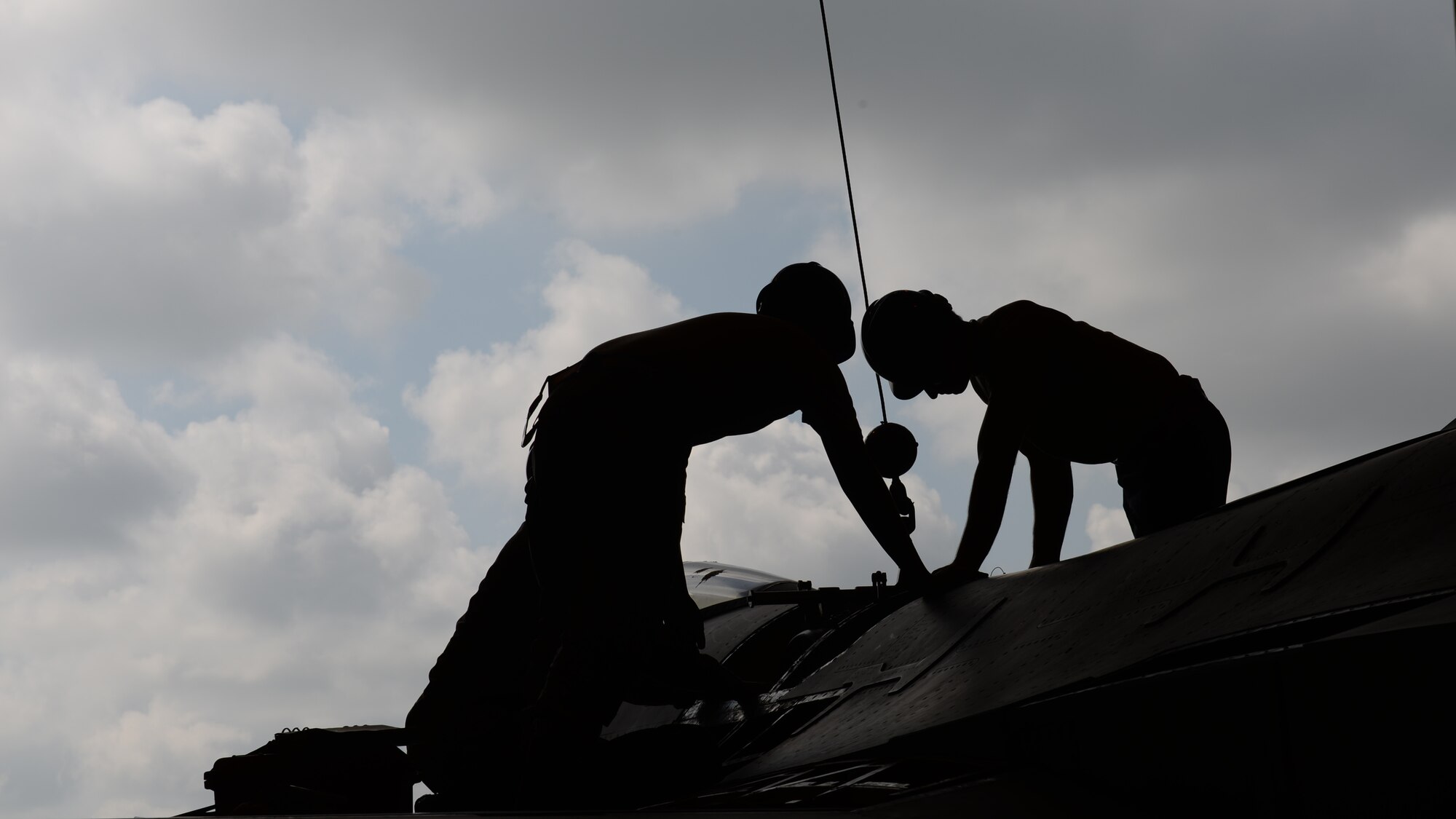 U.S. Air Force Airmen from the 31st Aircraft Maintenance Squadron attach a lift cable to a gun drum from an F-16 Fight Falcon’s gun bay during a phase inspection, June 15, 2015, at Aviano Air Base, Italy. The gun bay section received its 18-month extended inspection along with general maintenance. (U.S. Air Force Airman 1st Class Cary Smith/Released)