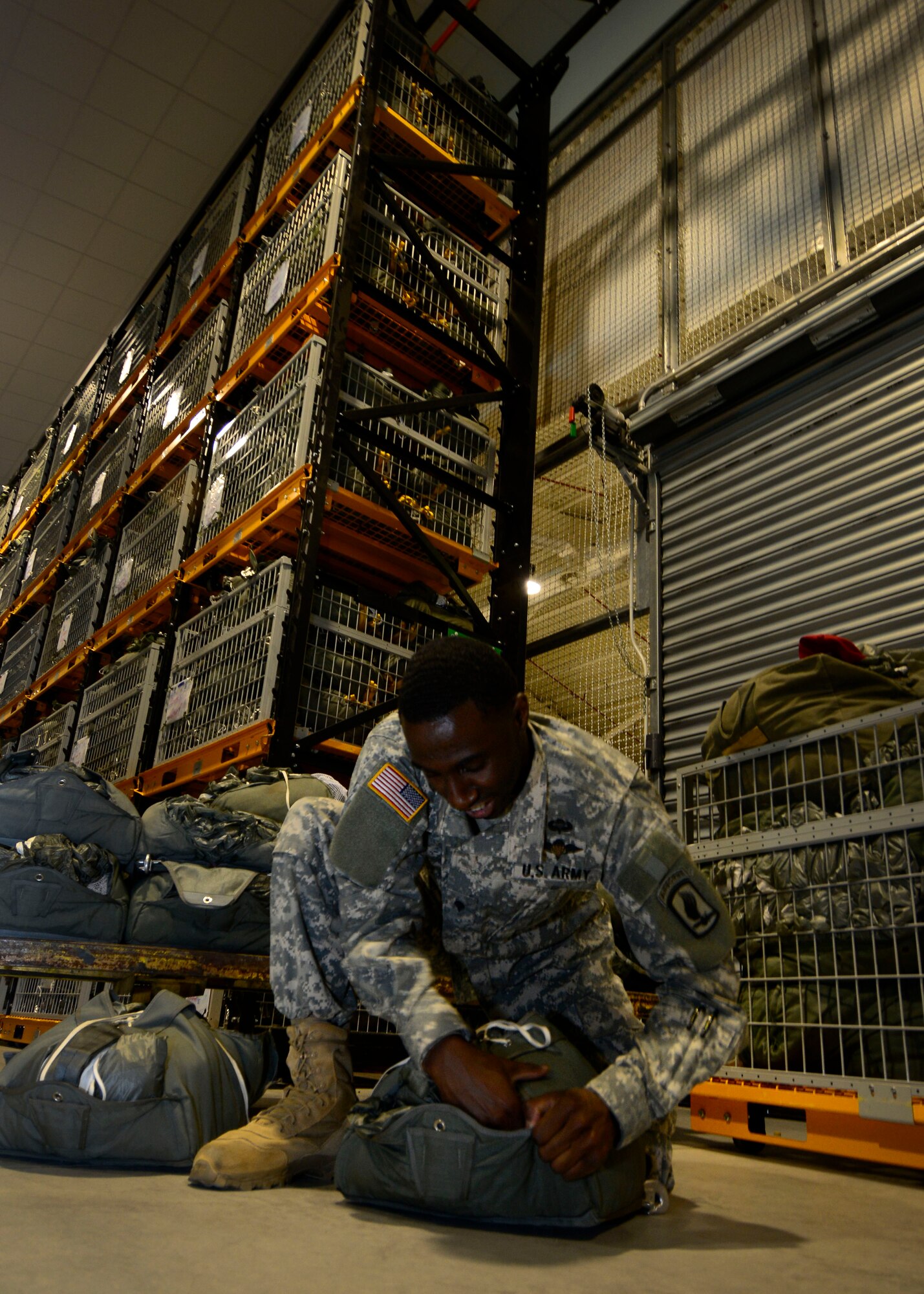 U.S. Army Spc. Jamarr Wilder, Headquarters and Headquarters Company 173rd Brigade Support Battalion parachute packer, ensure a parachute is properly packed, June 17, 2015, at Aviano Air Base, Italy. The unit packs more than 2,400 parachutes a month in preparation for jumps. (U.S. Air Force photo by Senior Airman Areca T. Wilson/Released)