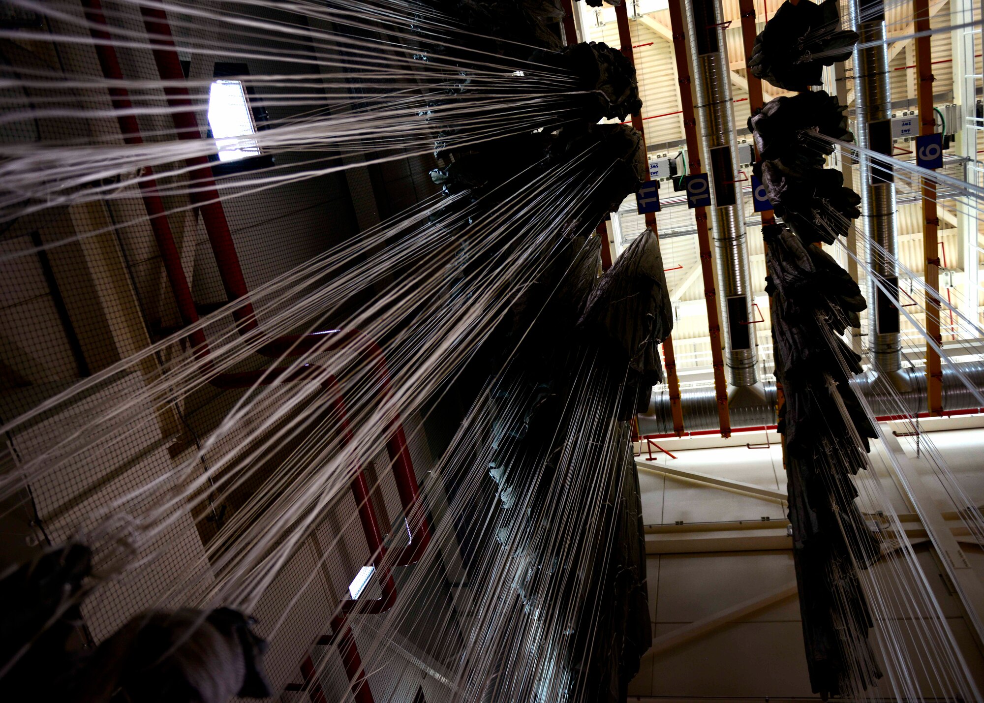 Parachutes hang in the tower to air dry, June 17, 2015, at Aviano Air Base, Italy. The parachutes are hung to prevent molding and to help remove debris that may have been tangled in it during jumps. (U.S. Air Force photo by Senior Airman Areca T. Wilson/Released)
