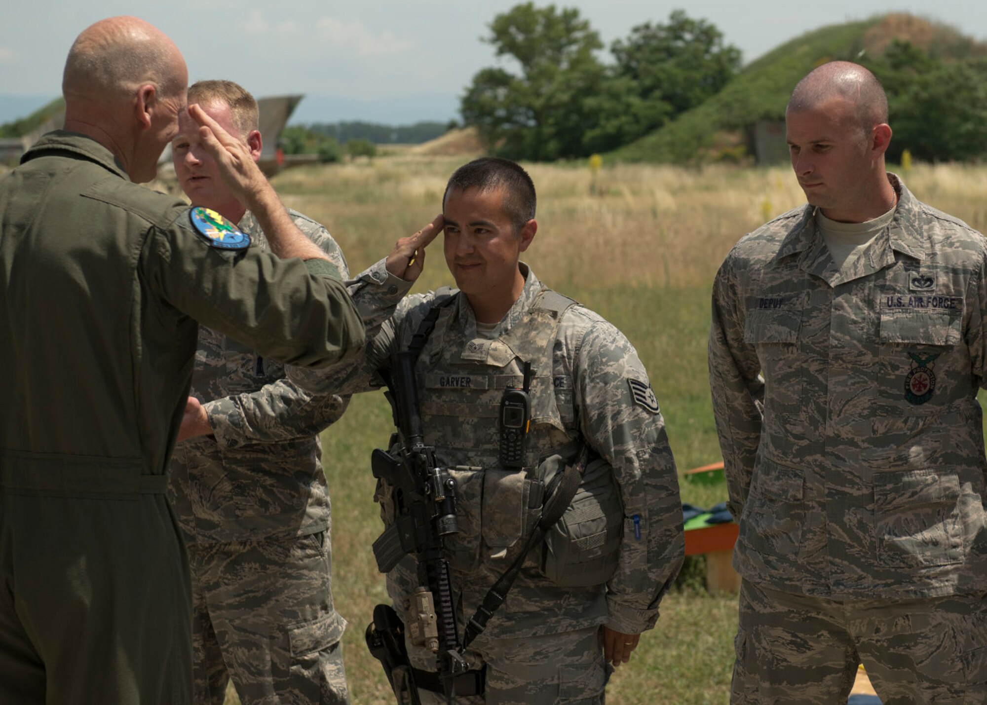 U.S. Air Force Brig. Gen. James O. Eifert returns a salute after giving a coin for excellence to Staff Sgt. Jonathan Garver for his volunteerism during his off-duty time at Graf Ignatievo Air Base, Bulgaria, June 10, 2015. Brig. Eifert, Florida Air National Guard assistant adjutant general, is on a site-visit to meet with Airmen deployed to the 159th Expeditionary Fighter Squadron in support of the theater security package. The combined efforts of the total force Airmen help maintain a global presence and strengthen relationships with NATO allies. Garver is a 52nd Security Forces Squadron defender from Spangdahlem Air Force Base, Germany. (U.S. Air Force photo/Tech. Sgt. Paul Villanueva II)