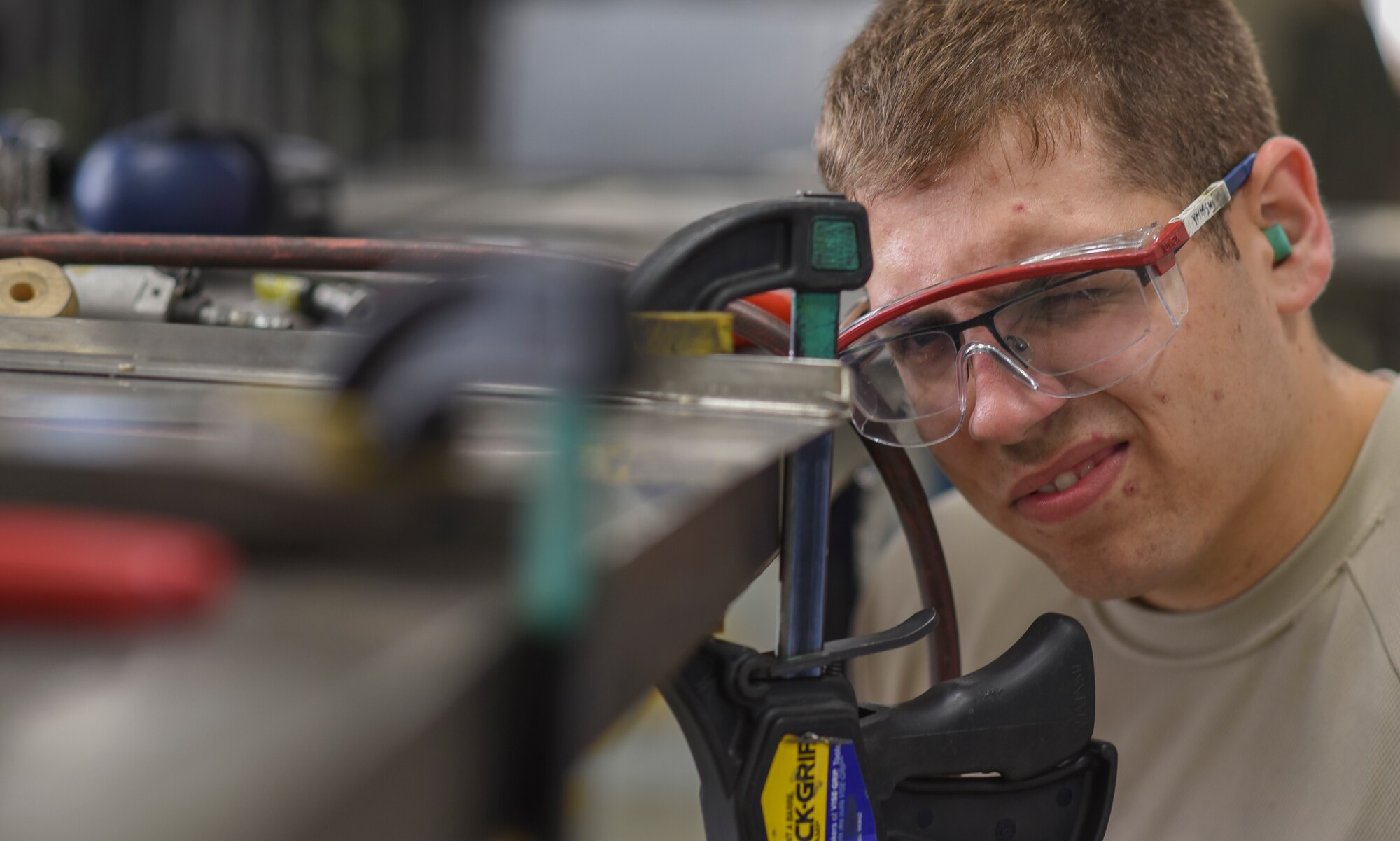 Airman 1st Class Jordan Pontius, 374th Maintenance Squadron Fabrication Flight aircraft structural maintainer, eyeballs his work after grinding down the bottom section of a steel cabinet door at Yokota Air Base, Japan, June 15, 2015. The fabrication flight can pretty much make anything the military needs. They’re only limited by the tools they have and their imagination. (U.S. Air Force photo by Senior Airman Michael Washburn/Released)