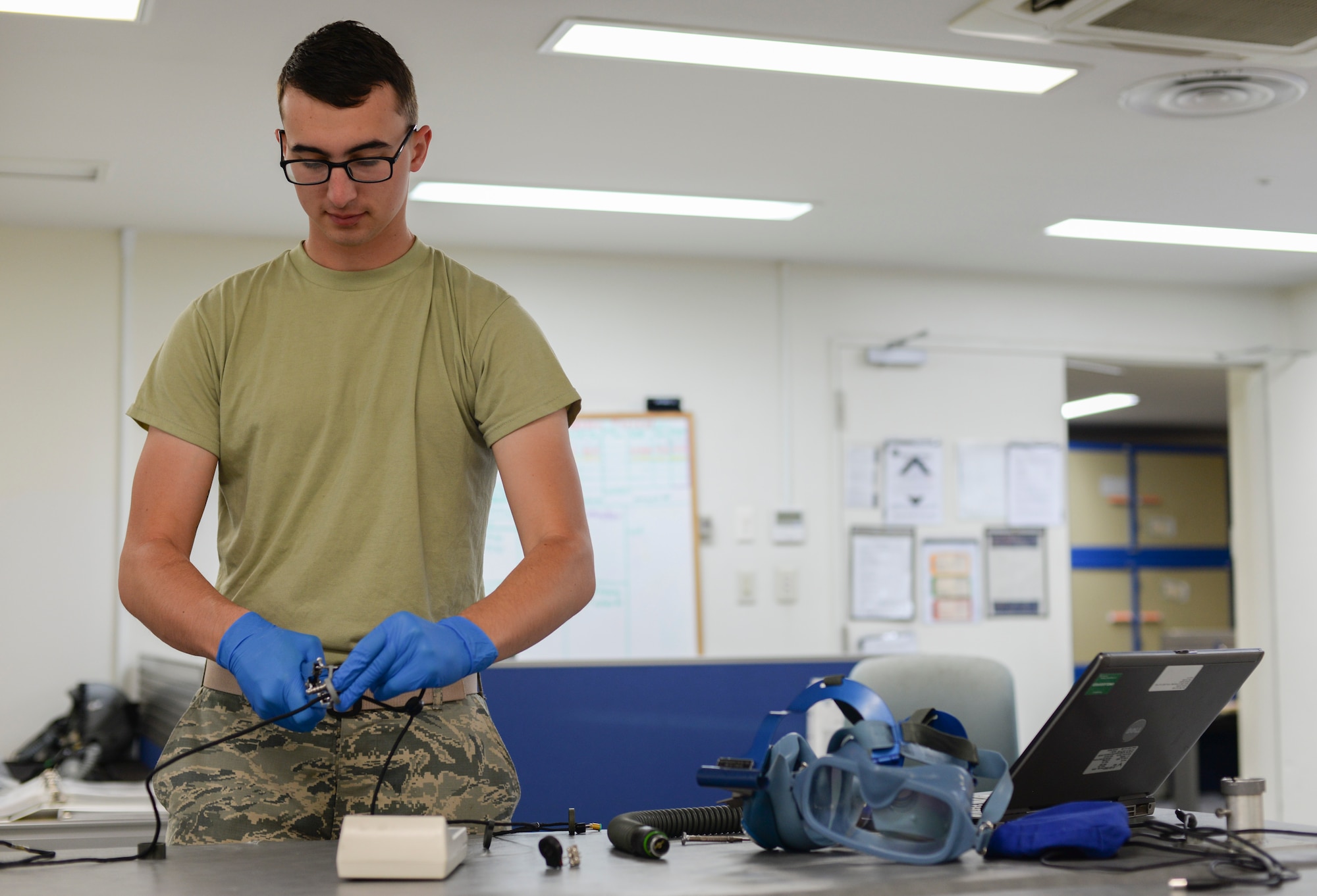 Airman 1st Class Colten Riggs, 374th Operations Support Squadron aircrew flight equipment apprentice, installs cable guides onto a communication wire at Yokota Air Base, Japan, June 16, 2015. The cable guides hold the communication wire in place so the flight crew can effectively communicate during missions. (U.S. Air Force photo by Senior Airman Michael Washburn/Released)