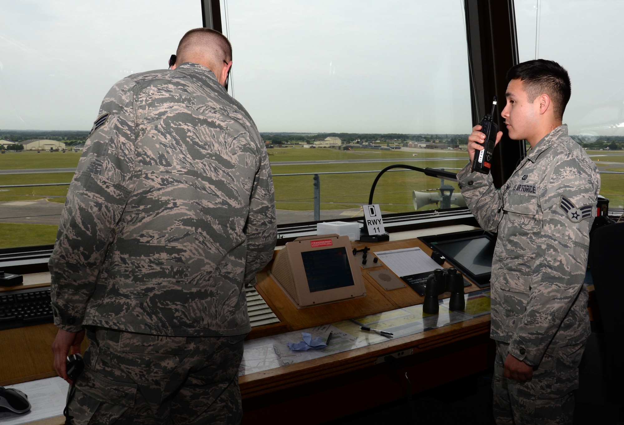 U.S. Air Force Senior Airman John Moreno, right, 100th Operations Support Squadron air traffic controller from Killeen, Texas, communicates with airfield management while U.S. Air Force Senior Airman Charles Allen, also a 100th OSS ATC from Riverside, Calif., copies information onto a flight progress strip June 16, 2015, on RAF Mildenhall, England. The job of an ATC is to talk to the pilots on the ground and in the air to ensure they travel safely. (U.S. Air Force photo by Gina Randall/Released)