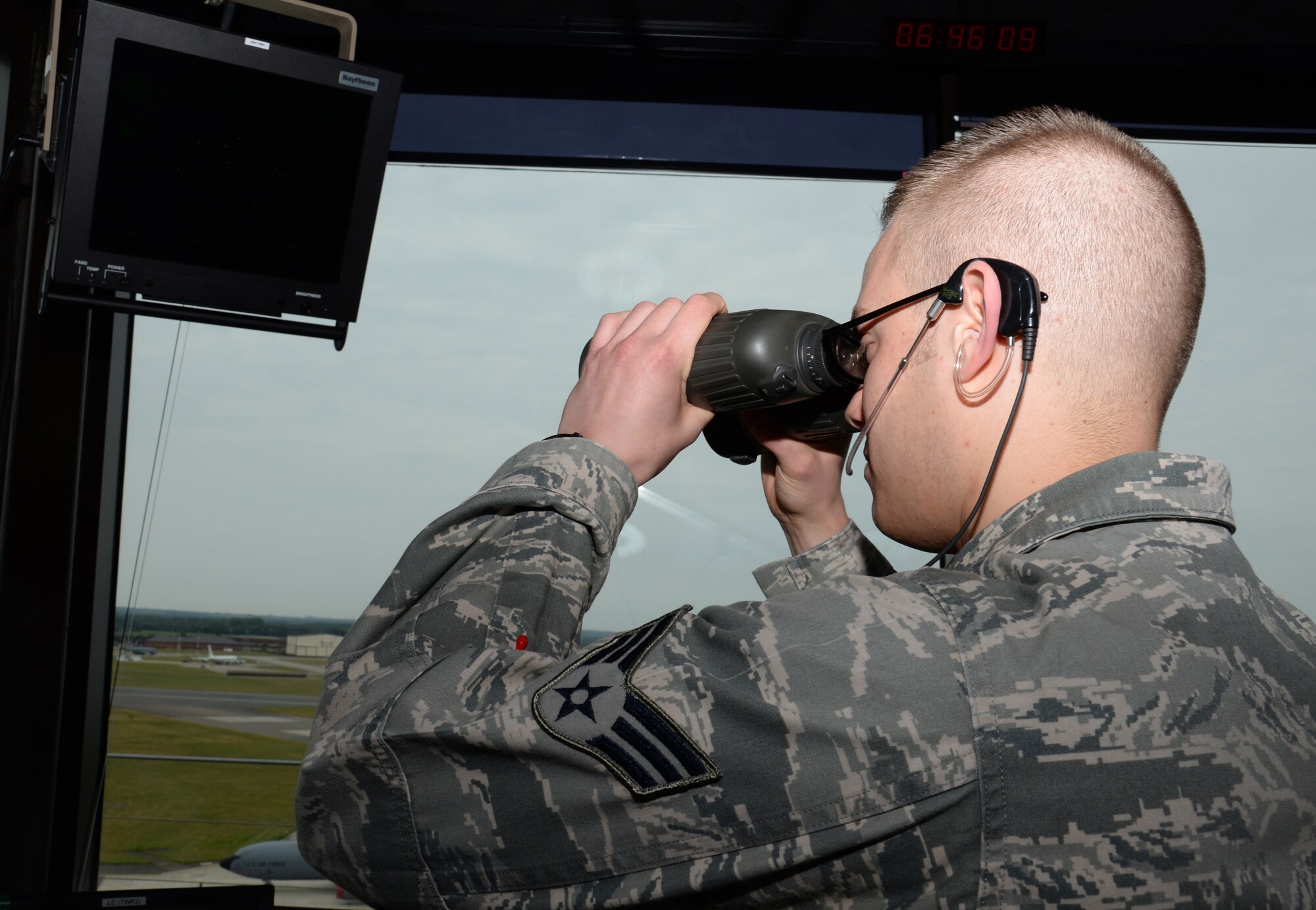U.S. Air Force Senior Airman Charles Allen, 100th Operations Support Squadron air traffic controller from Riverside, Calif., uses binoculars to watch an incoming aircraft June 16, 2015, on RAF Mildenhall, England. The job of an ATC is to control all the aircraft in the air and on the ground within five miles of the tower up to 2,000 feet. (U.S. Air Force photo by Gina Randall/Released)