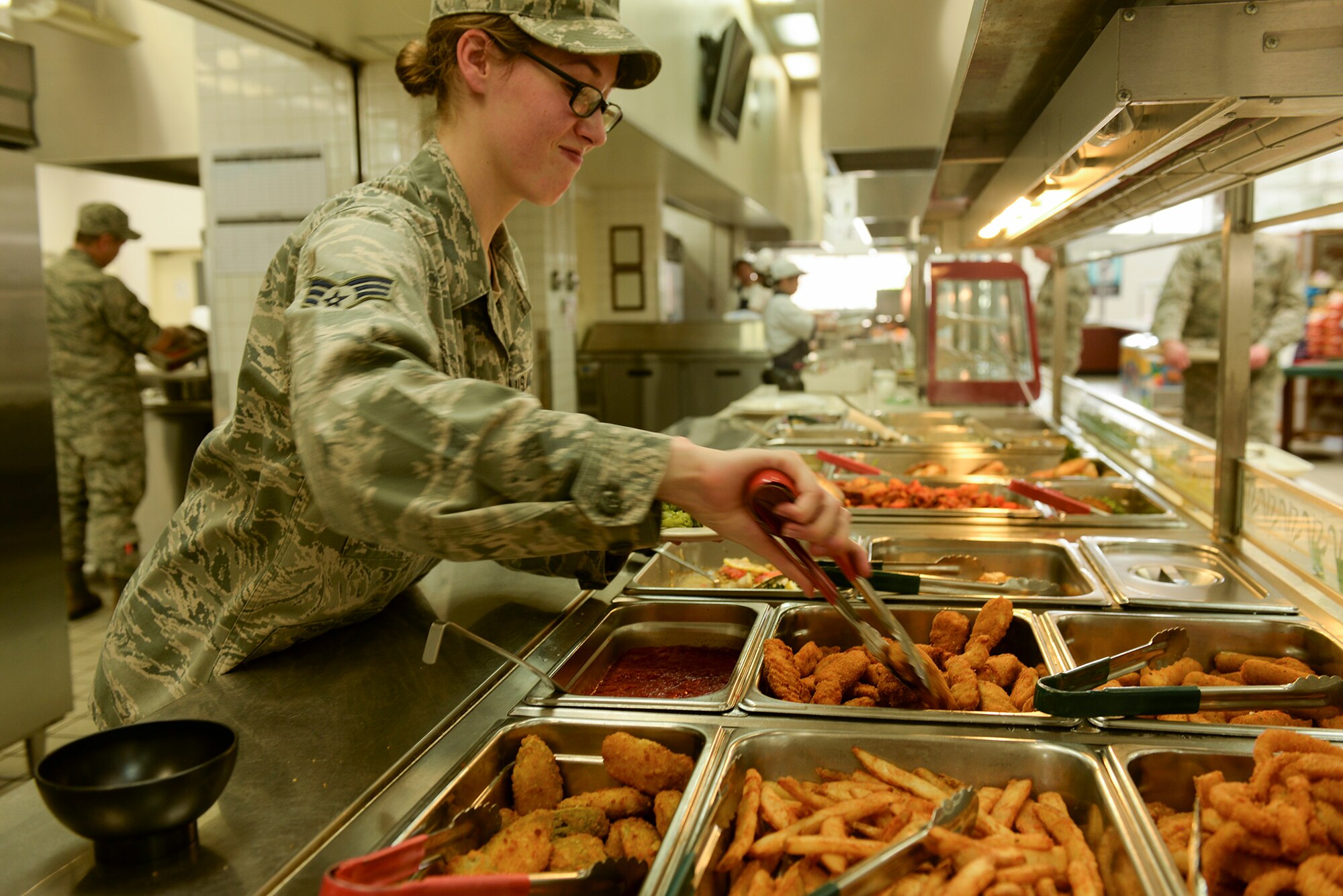 Senior Airman Tashina Bradley, 374th Force Support Squadron food services journeyman, serves lunch to Airmen at Yokota Air Base, Japan, June 15, 2015. The team at the Samurai Café says they are dedicated to providing the Yokota community with quality meals in a pleasant, relaxing environment. (U.S. Air Force photo by Airman 1st Class Elizabeth Baker/Released)