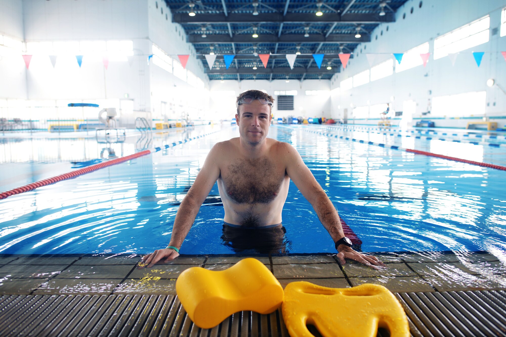 Navy Lt. Chadwick Shroy, a United States Forces Japan intelligence officer, poses in a swimming pool June 16, 2015, at Yokota Air Base, Japan. Shroy was performing physical training to ensure he's fit to flight. (U.S. Air Force photo by Airman 1st Class Delano Scott/Released)