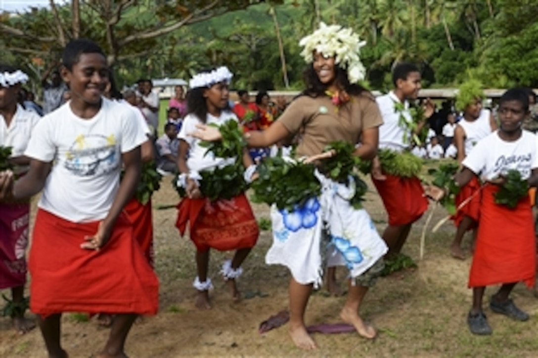 U.S. Navy Seaman Anaseini Taufa dances with children from the Viani Primary School during Pacific Partnership 2015 in Vanua Levu, Fiji, June 17, 2015. Marine and Fijian engineers worked together to build a new classroom at the school and celebrated with a ribbon-cutting ceremony.