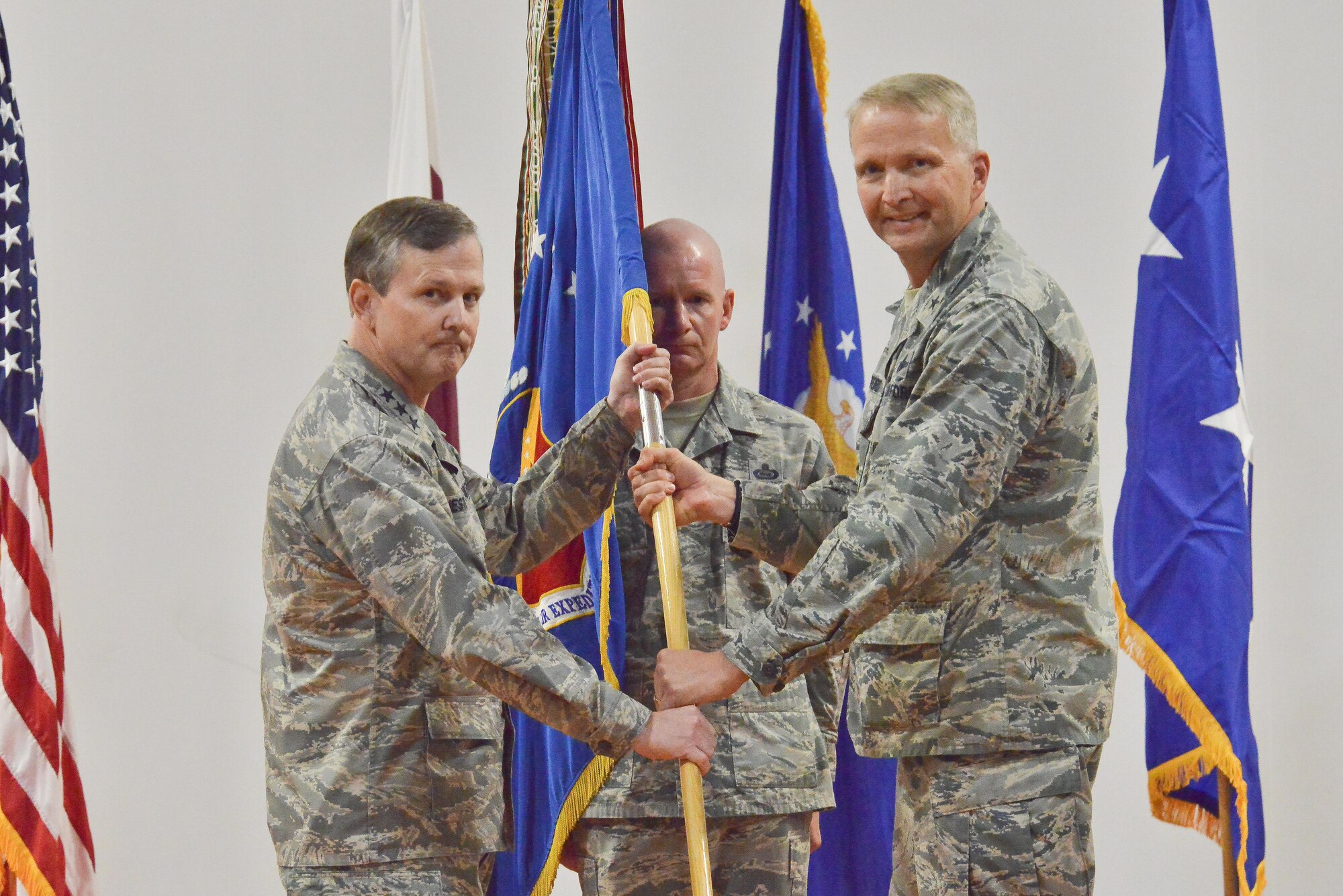 Lt. Gen. John Hesterman, U.S. Air Forces Central Command commander, receives the guidon from Brig. Gen. Darren Hartford as he relinquishes command of the 379th Air Expeditionary Wing June 14, 25015 Al Udeid Air Base, Qatar. Change of commands is a tradition that dates back to the Roman Legion in which authority is transferred from one commanding officer to another and is completed in front of the soldiers.  (U.S. Air Force photo/Staff Sgt. Alexandre Montes)