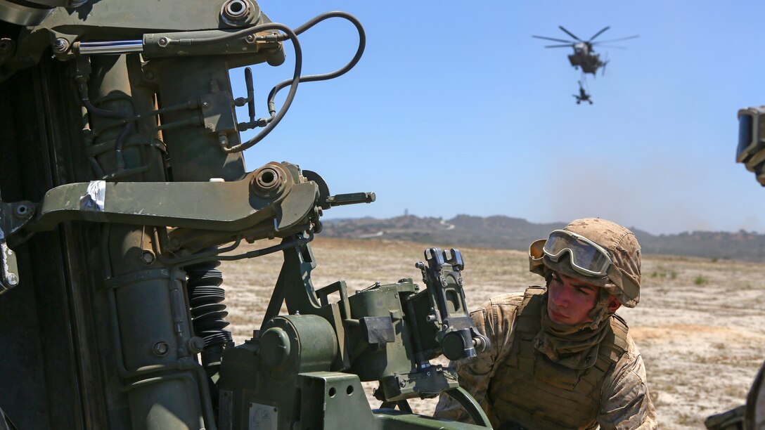 A Marine assigned to Company A, 1st Battalion, 11th Marine Regiment, 1st Marine Division, prepares an M777 howitzer to fire at Marine Corps Base Camp Pendleton, California June 17, 2015. CH-53E Super Stallions transported howitzers and ammunition as part of 1/11’s quarterly exercise to test the artillery Marine’s proficiency and ensure the Marines’ readiness.