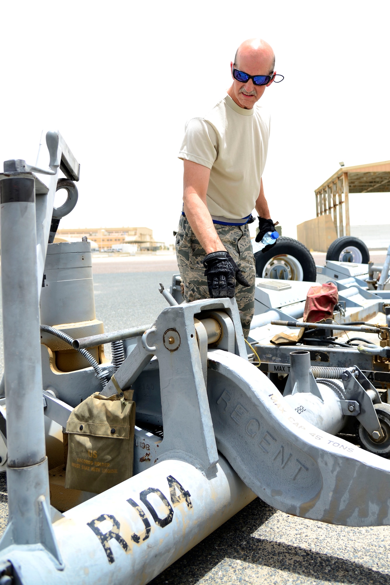 U.S. Air Force Tech. Sgt. Michial Smith, a 386th Expeditionary Aircraft Maintenance Squadron Aerospace Ground Equipment technician, conducts a shift-change equipment check at an undisclosed location in Southwest Asia, June 11, 2015. Smith, who deployed with his son, work in the same office, but on different shifts. (U.S. Air Force photo by Senior Airman Racheal E. Watson/Released)