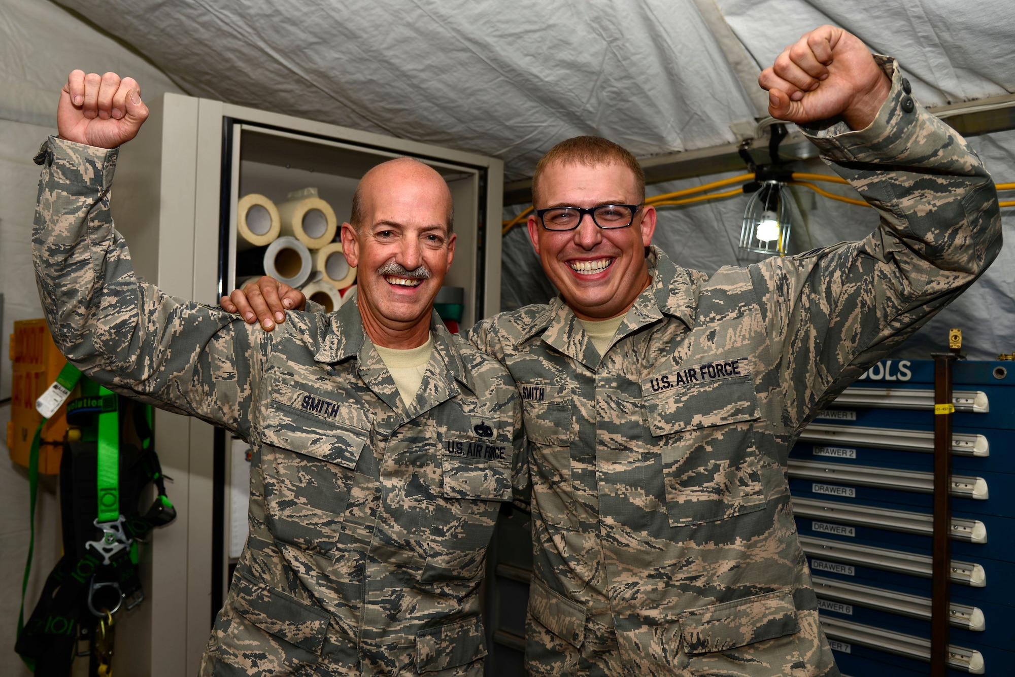 U.S. Air Force Tech. Sgt. Michial Smith, left, and Senior Airman Brandon Smith, 386th Expeditionary Aerospace Ground Equipment technicians, are deployed together as father and son at an undisclosed location in Southwest Asia, June 11, 2015. The Smith duo is stationed at Pittsburgh International Airport Air Reserve Station in Pennsylvania. (U.S. Air Force photo by Senior Airman Racheal E. Watson/Released)