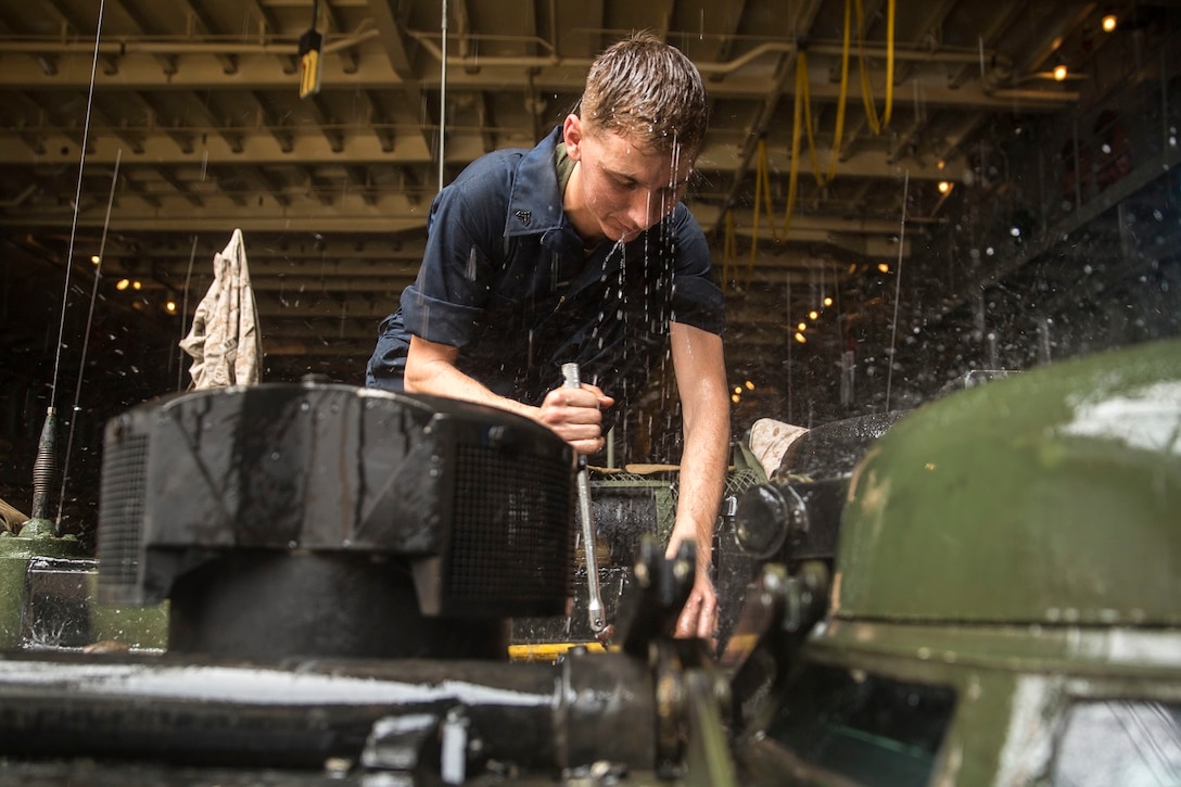 U.S. Marine Cpl. Kevin Versluis loosens bolts on an AAV-7 Amphibious Assault Vehicle during vehicle maintenance aboard USS Rushmore (LSD 47) at sea in the Strait of Malacca, June 15, 2015. Versluis is an AAV crew chief with Kilo Company, Battalion Landing Team 3rd Battalion, 1st Marine Regiment, 15th Marine Expeditionary Unit. Versluis and his crew were replacing the hydrostatic steering unit, a component that controls the vehicle’s steering. (U.S. Marine Corps photo by Sgt. Emmanuel Ramos/Released)