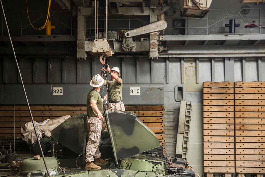 U.S. Marines with Kilo Company, Battalion Landing Team 3rd Battalion, 1st Marine Regiment, 15th Marine Expeditionary Unit, remove the plenums from an AAV-7 Amphibious Assault Vehicle during vehicle maintenance aboard USS Rushmore (LSD 47) at sea in the Strait of Malacca, June 15, 2015. AAV crewmen were replacing the hydrostatic steering unit, a component that controls the vehicle’s steering. (U.S. Marine Corps photo by Sgt. Emmanuel Ramos/Released)