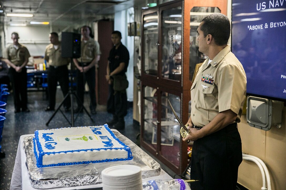 U.S. Sailors and Marines with the Essex Amphibious Ready Group and 15th Marine Expeditionary Unit join to celebrate the Hospital Corps’ 117th birthday aboard the USS Essex (LHD 2) at sea in the Indian Ocean, June 17, 2015. During the ceremony, the oldest and youngest Hospital Corpsman cut the cake together, signifying knowledge passing from the older to the younger generation. (U.S. Marine Corps photo by Cpl. Anna Albrecht/ Released)