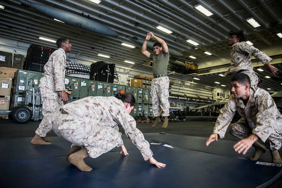U.S. Marines with the 15th Marine Expeditionary Unit execute combat conditioning exercises during Marine Corps Martial Arts Program aboard the USS Essex (LHD 2) at sea in the Indian Ocean, June 18, 2015. MCMAP focuses on hand-to-hand combat and teaches the Marines about their core values, benefitting each of them mentally and physically. (U.S. Marine Corps photo by Cpl. Anna Albrecht/ Released)