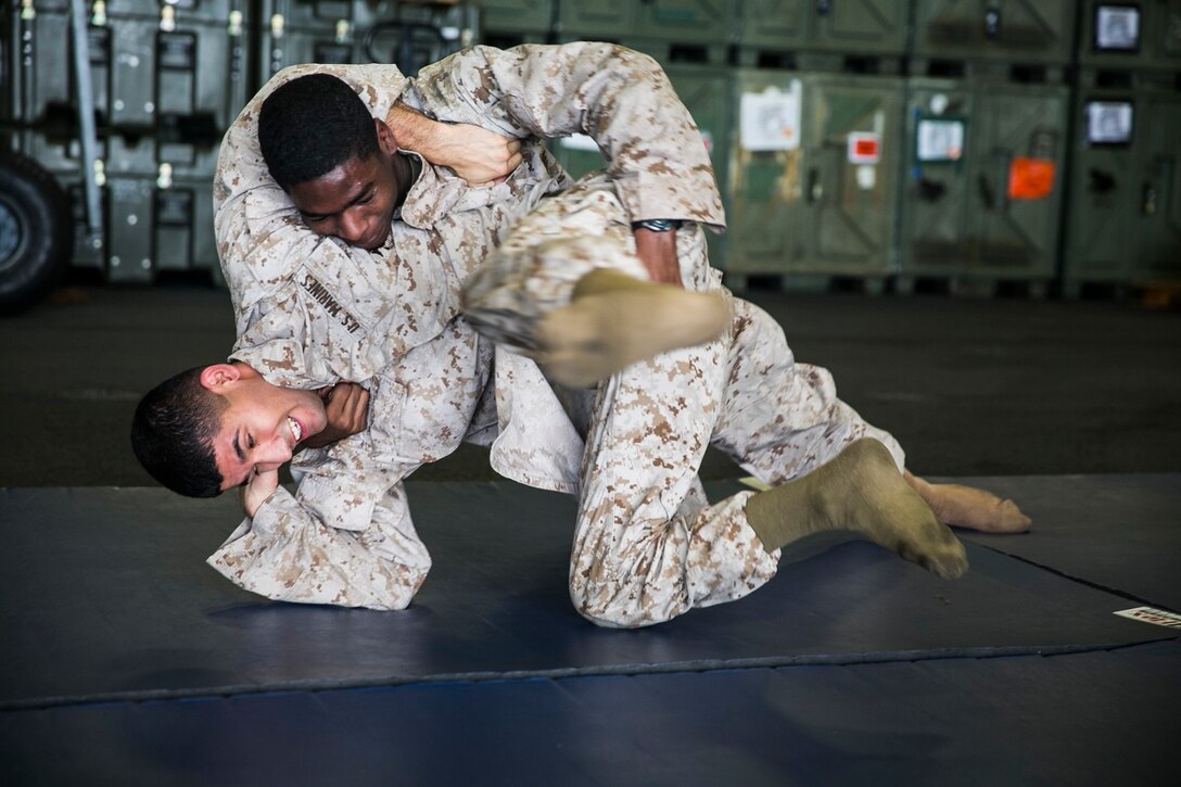 U.S. Marine Cpl. Adrian Juarez, left, grapples with Lance Cpl. D’vonte Robinson aboard during Marine Corps Martial Arts Program aboard the USS Essex (LHD 2) at sea in the Indian Ocean, June 18, 2015. Juarez is a field radio operator and Robinson is an administrative specialist with the 15th Marine Expeditionary Unit. MCMAP focuses on hand-to-hand combat and keeps the Marines in a combat mindset while deployed. (U.S. Marine Corps photo by Cpl. Anna Albrecht/ Released)
