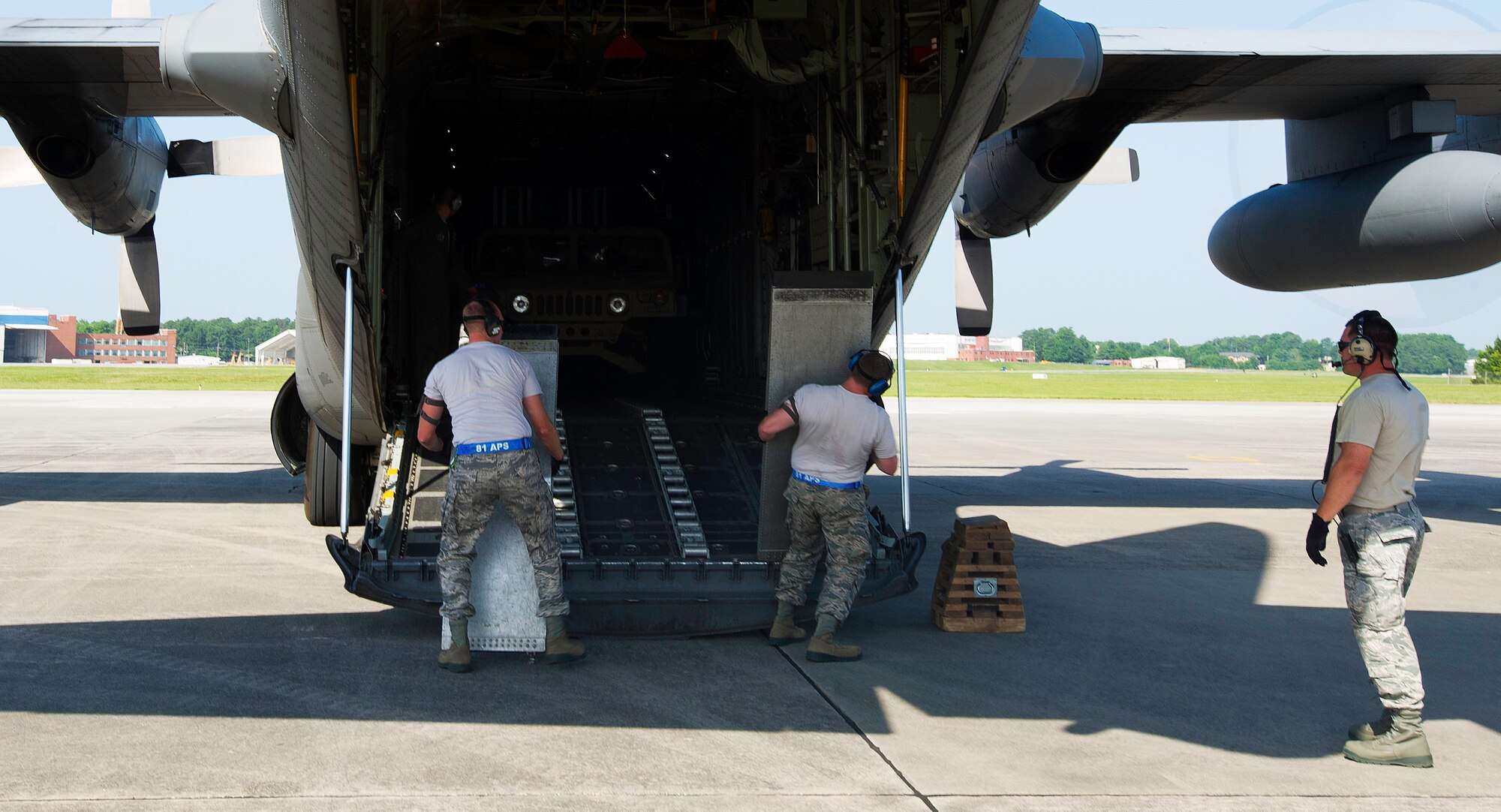 U.S. Air Force Staff Sgt. Thomas Mitchum (left) and Master Sgt. Joe Speer (right), 81st Aerial Port Squadron Port Dawg Challenge participants, remove loading ramps from a C-130 Hercules during an aerial port engine running on-load challenge at Dobbins Air Reserve Base, Ga., June 16, 2015. The Port Dawg Challenge was created to enhance and maintain the camaraderie, esprit de corps and prestige of aerial port Airmen while promoting professionalism, leadership, training and communication between "Port Dawgs." (U.S. Air Force photo by Senior Airman Josh Slavin/Released)