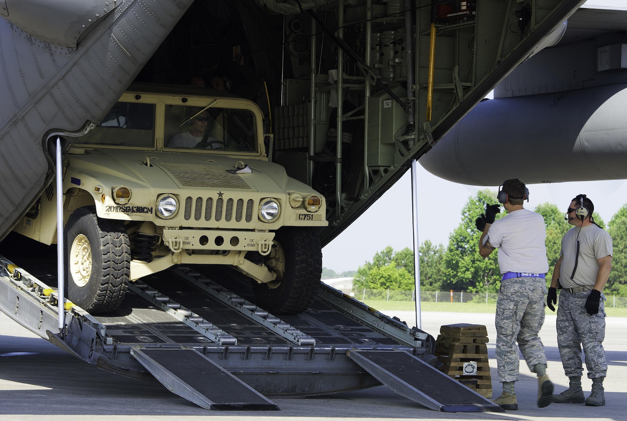 U.S. Air Force Tech. Sgt. Chris Giradeau, 81st Aerial Port Squadron Port Dawg Challenge participant, uses hand signals to guide Master Sgt. Seth Soine, 81st APS Port Dawg Challenge participant, out the back of a C-130 Hercules during an aerial port engine running on-load challenge at Dobbins Air Reserve Base, Ga., June 16, 2015. The Port Dawg Challenge was created to enhance and maintain the camaraderie, esprit de corps and prestige of aerial port Airmen while promoting professionalism, leadership, training and communication between "Port Dawgs." (U.S. Air Force photo by Senior Airman Josh Slavin/Released)