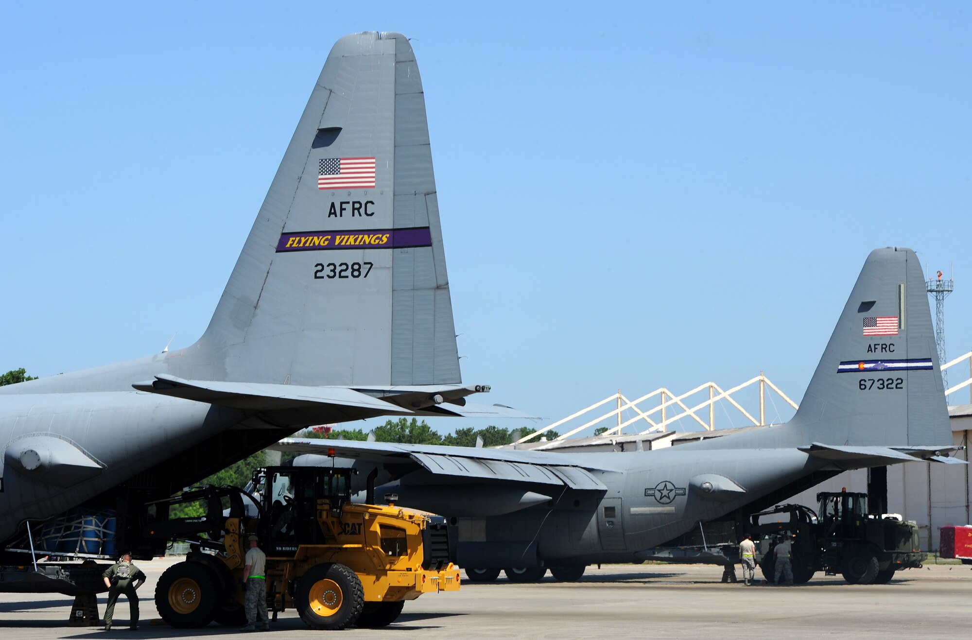 U.S. Air Force members competing in the Aerial Port Engine Running On-load (ERO) load cargo onto a C-130 Hercules aircraft during the Port Dawg Challenge at Dobbins Air Reserve Base, Ga., June 16, 2015. The Port Dawg Challenge was created to enhance and maintain the camaraderie, esprit de corps and prestige of aerial port Airmen while promoting professionalism, leadership, training and communication between "Port Dawgs." (U.S. Air Force photo by Tech. Sgt. Stephen D. Schester/Released)