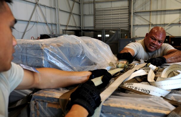 U.S. Air Force Senior Airman Matthew Mira, left, and Staff Sgt. Philip Blas, both assigned to the 44th Aerial Port Squadron, work together to tighten down cargo straps during the pallet build up portion of the Port Dawg Challenge at Dobbins Air Reserve Base, Ga., June 17, 2015. The Port Dawg Challenge was created to enhance and maintain the camaraderie, esprit de corps and prestige of aerial port Airmen while promoting professionalism, leadership, training and communication between "Port Dawgs." (U.S. Air Force photo by Tech. Sgt. Stephen D. Schester/Released)