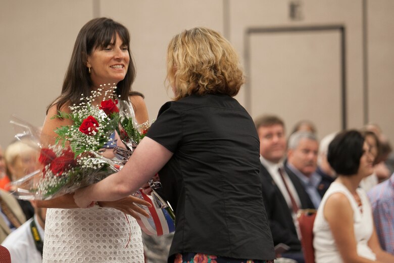Sheri Tickner, wife of outgoing Savannah District Commander Col. Thomas J. Tickner, is presented with a bouquet of roses at the Change of Command ceremony held at the Hyatt Regency Hotel June 19. Tickner relinquishes command after his two-year tenure where he oversaw completion of Project Partnership Agreement between the state of Georgia and the Corps of Engineers outlining funding for the Savannah Harbor Expansion Project. He also oversaw the beginning of construction of the Savannah harbor deepening. 