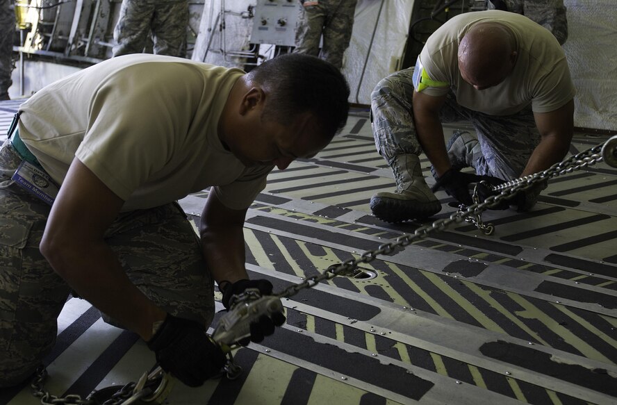 U.S. Air Force Tech. Sgt. Tom Limtiaco (left) and Staff Sgt. Philip Blas, 44th Aerial Port Squadron Port Dawg Challenge participants, tighten the cargo hold chains while completing the cargo restraint challenge at Dobbins Air Reserve Base, Ga., June 16, 2015. The Port Dawg Challenge was created to enhance and maintain the camaraderie, esprit de corps and prestige of aerial port Airmen while promoting professionalism, leadership, training and communication between "Port Dawgs." (U.S. Air Force photo by Senior Airman Josh Slavin/Released)