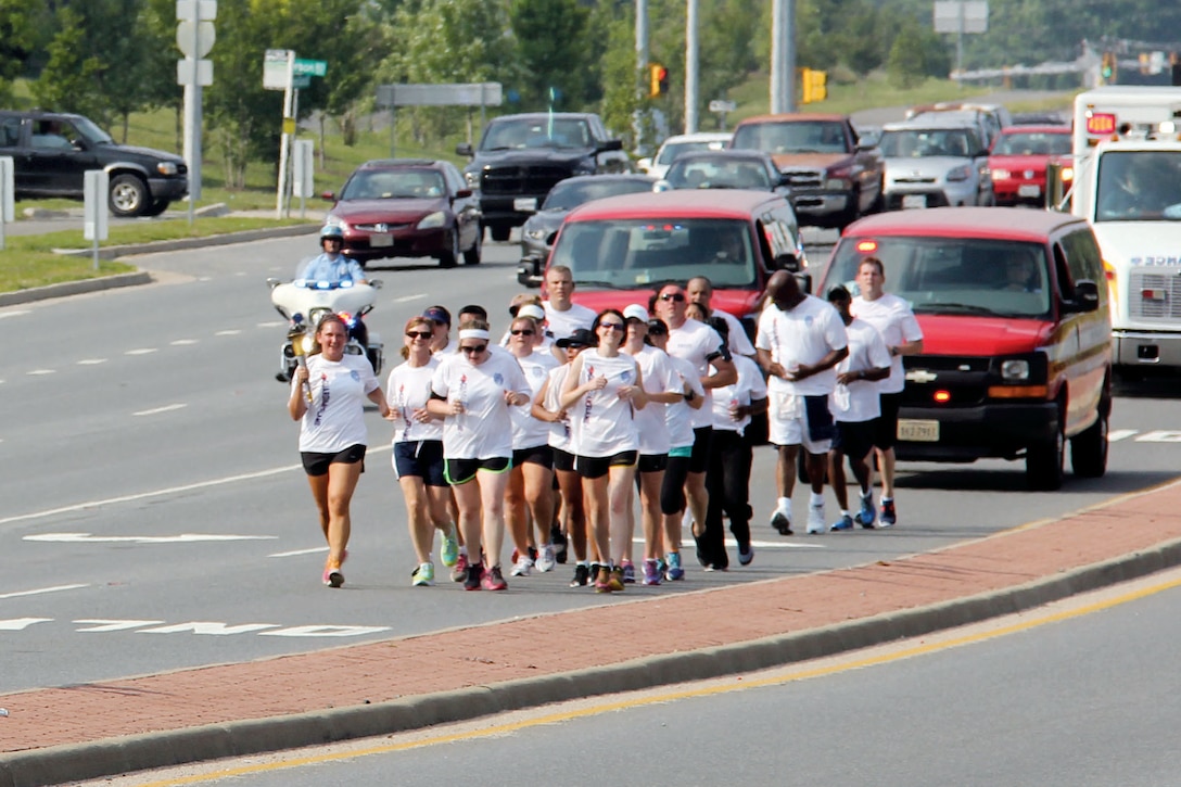 Members of the Prince William County Police Department carry the torch southbound on US Route 1, June 11. The officers took part in the Law Enforcement torch run to raise awareness and funds for Special Olympics Virginia. 