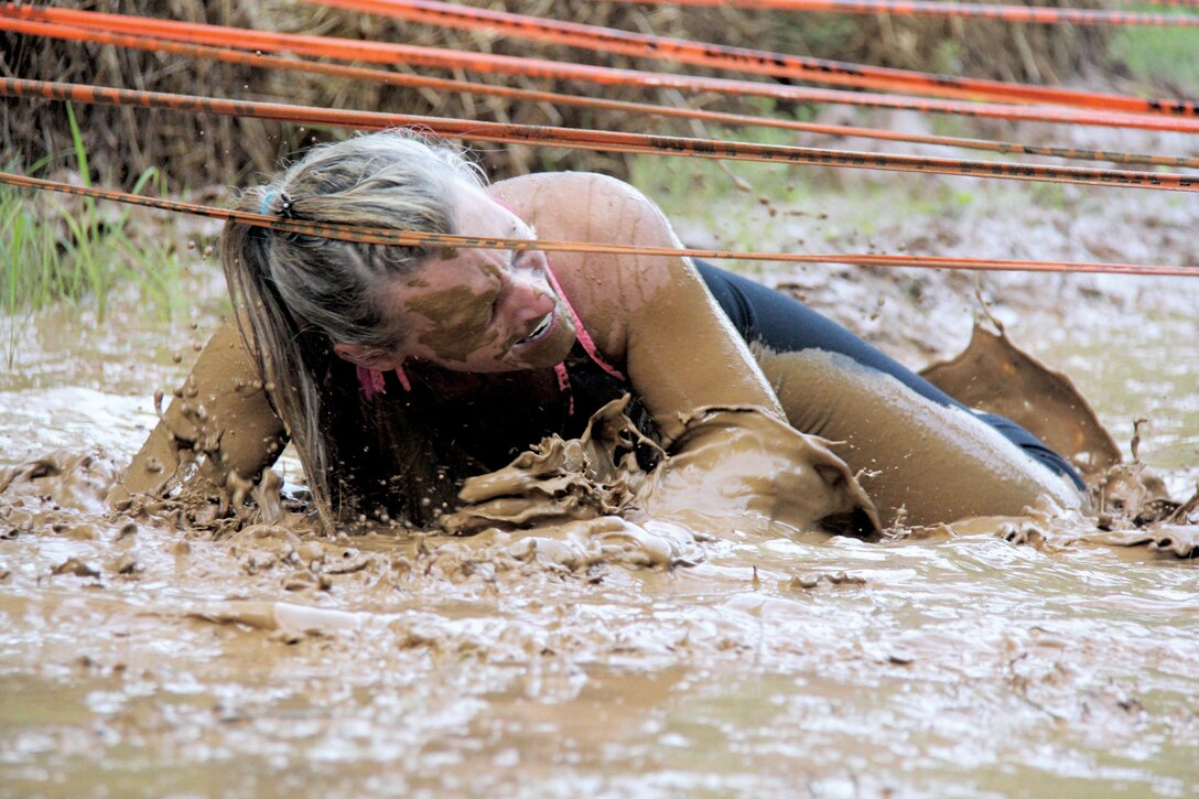Laura Dosser crawls through the mud at the Run Amuck race, June 13, Marine Corps Base Quantico. 