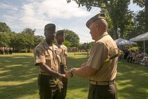 Sgt. Maj. Michael Jones (left) passes his sword to Lt. Gen. Robert Neller (right) during a relief and appointment ceremony aboard Naval Support Activity Hampton Roads, Va., June 19, 2015. The passing of the sword is a tradition in the Marine Corps representing the relinquishment of duties. Jones received the Legion of Merit with gold star and retired after 32 years of service in the Marine Corps. Sgt. Maj. Christopher Robinson (center) assumed the duties of U.S. Marine Corps Forces Command sergeant major. (USMC photo by Steve Kotecki/RELEASED)