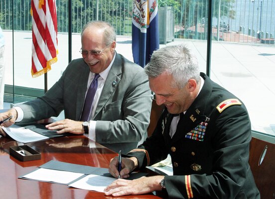 John Reinhart, CEO and executive director of the Virginia Port Authority and Colonel Paul Olsen, Norfolk District, U.S. Army Corps of Engineer's commander, sign the feasibility cost-share agreement, which commits each side to sharing the cost of evaluating the benefits of two dredging projects critical to the future of Norfolk Harbor. 