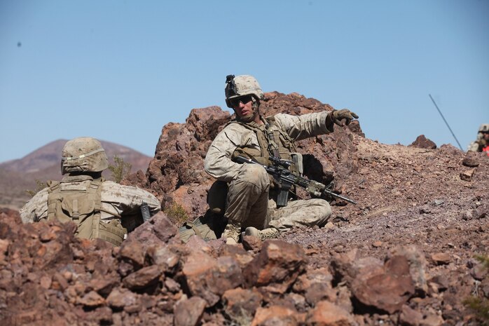 A sergeant with Company A, 1st Battalion, 7th Marine Regiment, 1st Marine Division, I Marine Expeditionary Force, directs his Marines into position atop a berm during 1/7’s Marine Corps Combat Readiness Evaluation aboard Twentynine Palms, Calif., June 9, 2015.  Marines from 1/7 and 2nd battalion, 7th Marine Regiment are currently in preparation for deployment with the Special Purpose Marine Air Ground Task Force (SPMAGTF) scheduled to depart in support of Operation Inherent Resolve later this year.