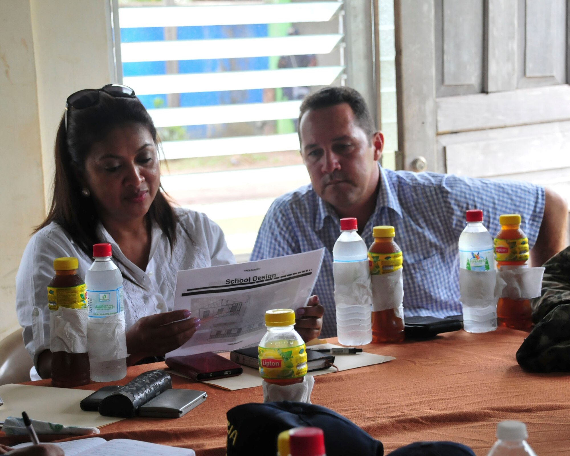 PUERTO LEMPIRA, Honduras – Marelin Bendles, the Ministry of Education representative for Gracias a Dios Department, and Alberto Haylock, the Governor of Gracias a Dios Department, review plans for a school to be built by the Special Purpose Marine Air Ground Task Force-Southern Command, during a bi-lateral meeting in Puerto Lempira, Honduras, June 18, 2015. The SPMAGTF-SC is based out of Soto Cano Air Base, Honduras, through November 2015 and plans to build two additional schools in Gracias a Dios, along with a road and airfield construction project. (U.S. Air Force Photo by Capt. Christopher Love)