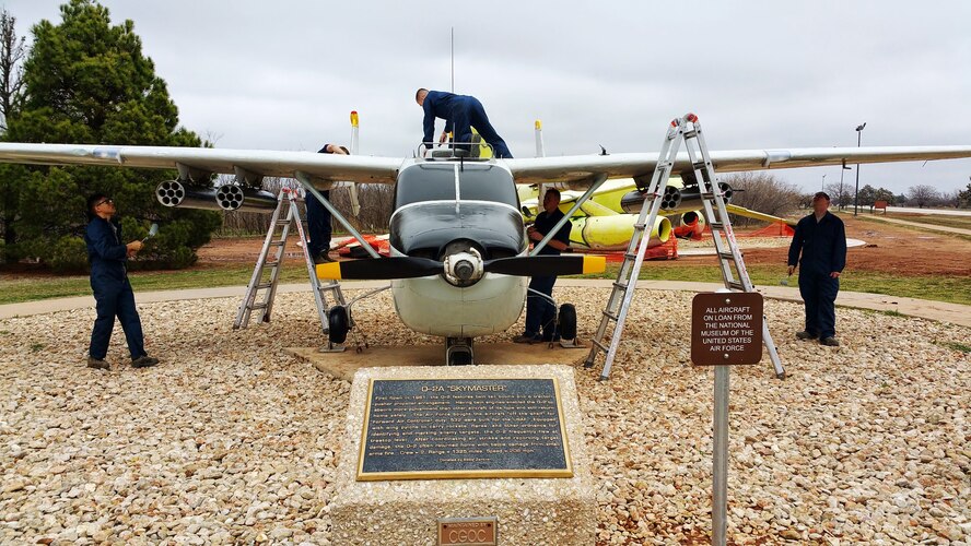 Dyess Airmen paint an O-2A Skymaster at the Linear Air Park March 10, 2015, at Dyess Air Force Base, Texas. More than 120 volunteers contributed more than 114,000 man hours over the course of seven weeks to complete a major restoration project of all 36 aircraft in the outdoor exhibit. (Courtesy photo)

