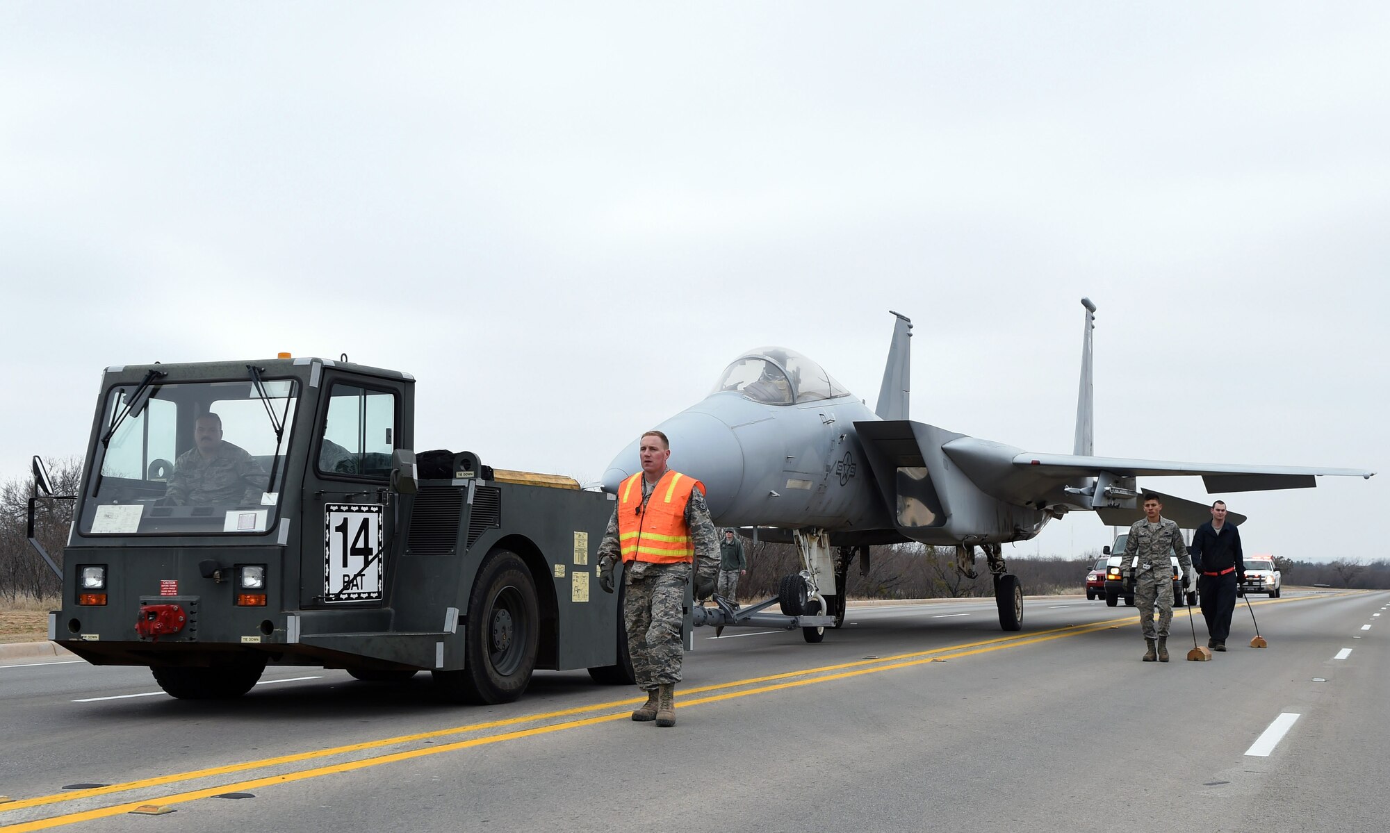 Dyess Airmen escort an F-15A Eagle to its new location Feb. 21, 2015, at Dyess Air Force Base. The F-15A is one of the new aircraft that was installed during a major project to improve and restore the Dyess Linear Air Park. (U.S. Air Force photo by Staff Sgt. Joel Mease/Released)