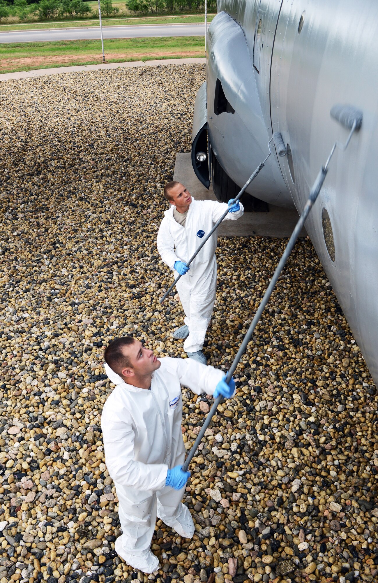 U.S. Air Force Airman 1st Class Jacob Wood, left, and Senior Airman Brandon Bartling, both assigned to the 7th Equipment Maintenance Squadron aircraft structural maintenance section, repaint a C-130E Hercules June 12, 2015, at Dyess Air Force Base, Texas. Airmen from the 317th Airlift Group, children from the Youth Center and other volunteers contributed to refurbishing the C-130E, which was the final aircraft to be restored in the Dyess Linear Air Park. (U.S. Air Force photo by Airman 1st Class Kedesha Pennant/Released)