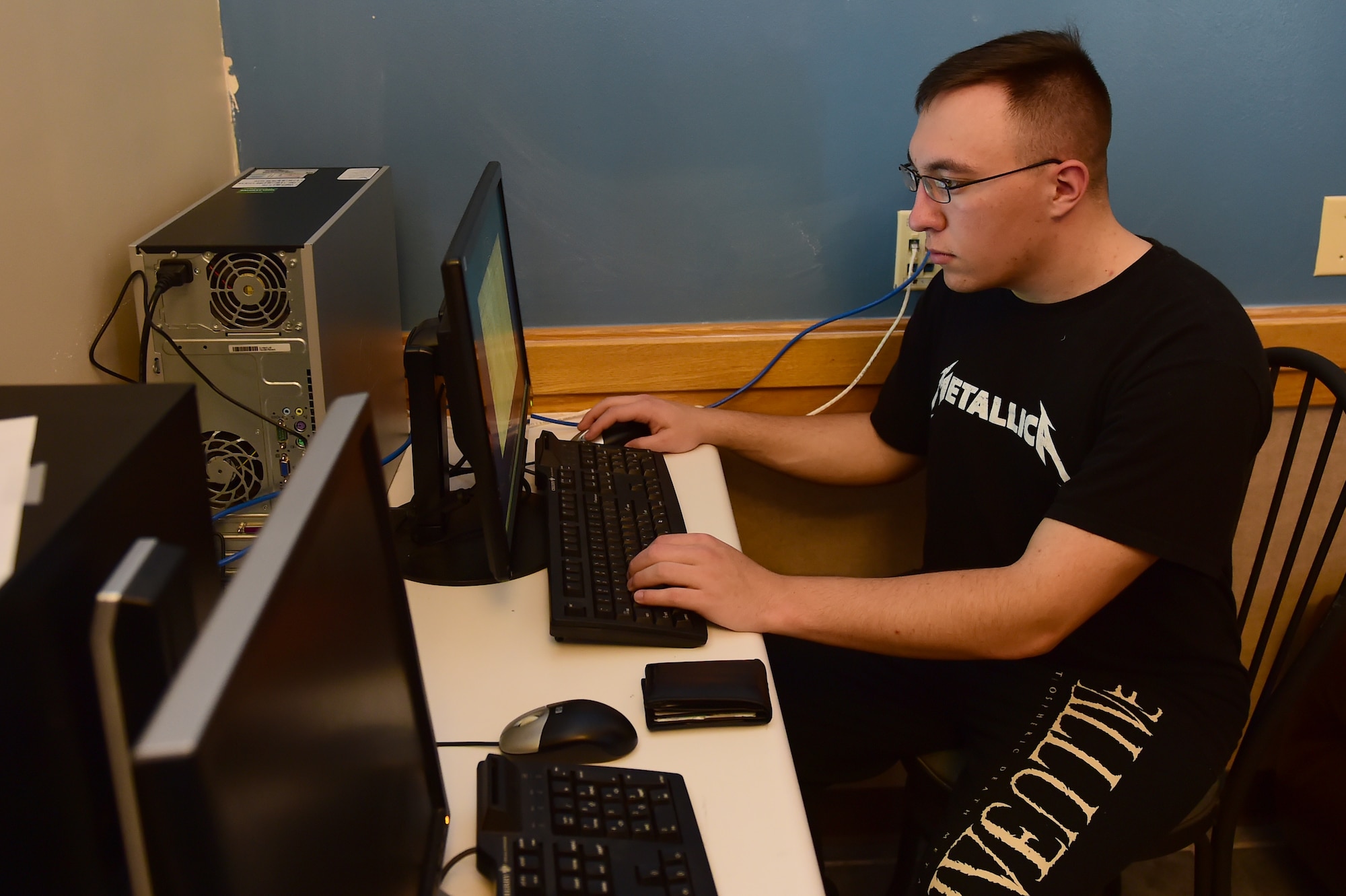 Senior Airman Nicholas Heaton, 460th Space Wing network administrator, uses the new computers installed in Panther Hall to check his email June 19, 2015, at Buckley Air Force Base, Colo. A new Non-Secure Internet Protocol Router café has been built for Panther Hall members so they can have secure internet access in the dorm. (U.S. Air Force photo by Airman 1st Class Luke W. Nowakowski/Released)
