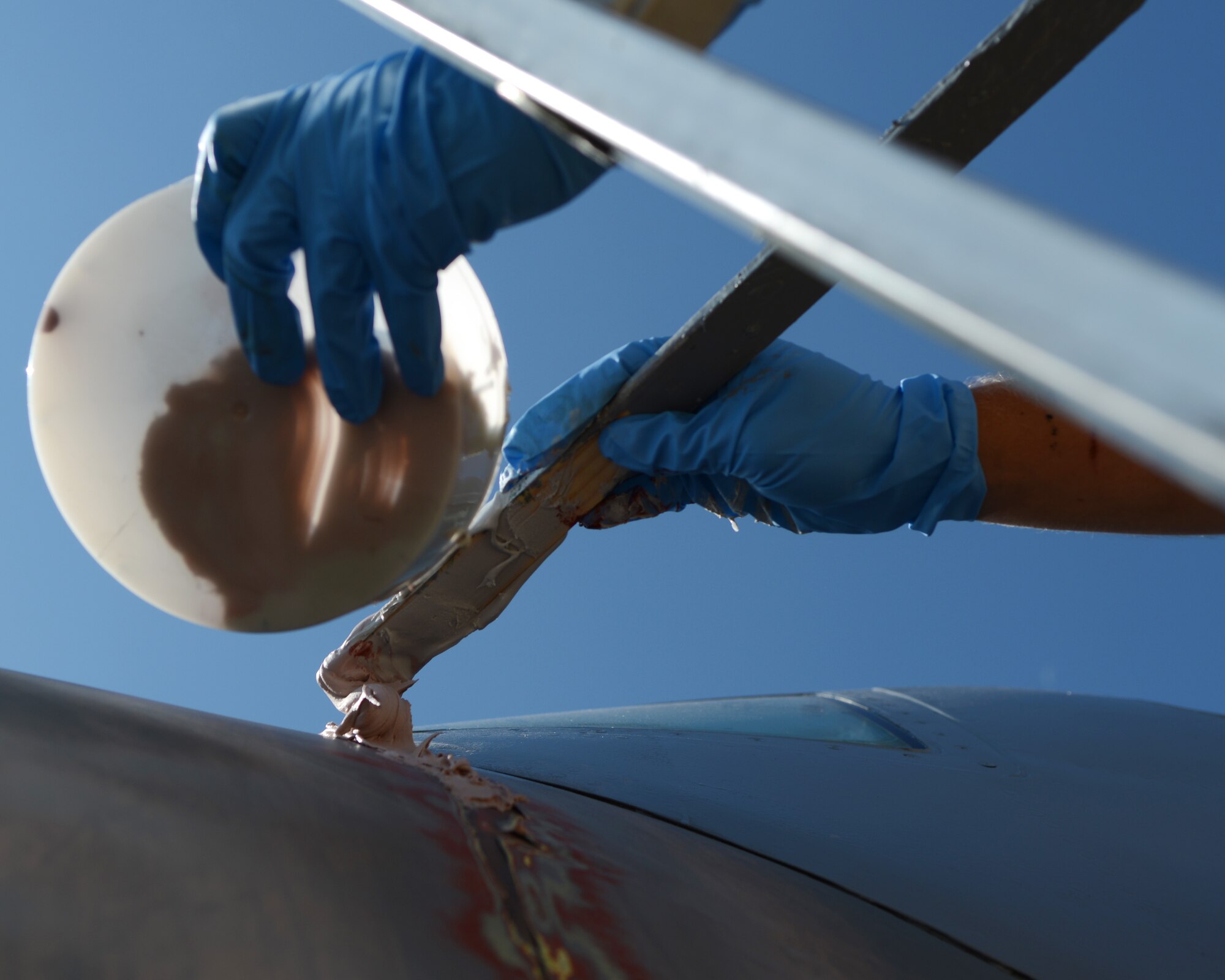 U.S. Air Force Senior Airman Brandon Bartling, 7th Equipment Maintenance Squadron aircraft structural maintenance journeyman, applies body filler to a C-130E Hercules June 11, 2015, at Dyess Air Force Base, Texas.  More than 120 volunteers helped refurbish the Dyess Linear Air Park by repainting, bird-proofing, sanding, washing and repairing its 36 aircraft. (U.S. Air Force photo by Airman 1st Class Kedesha Pennant/Released)