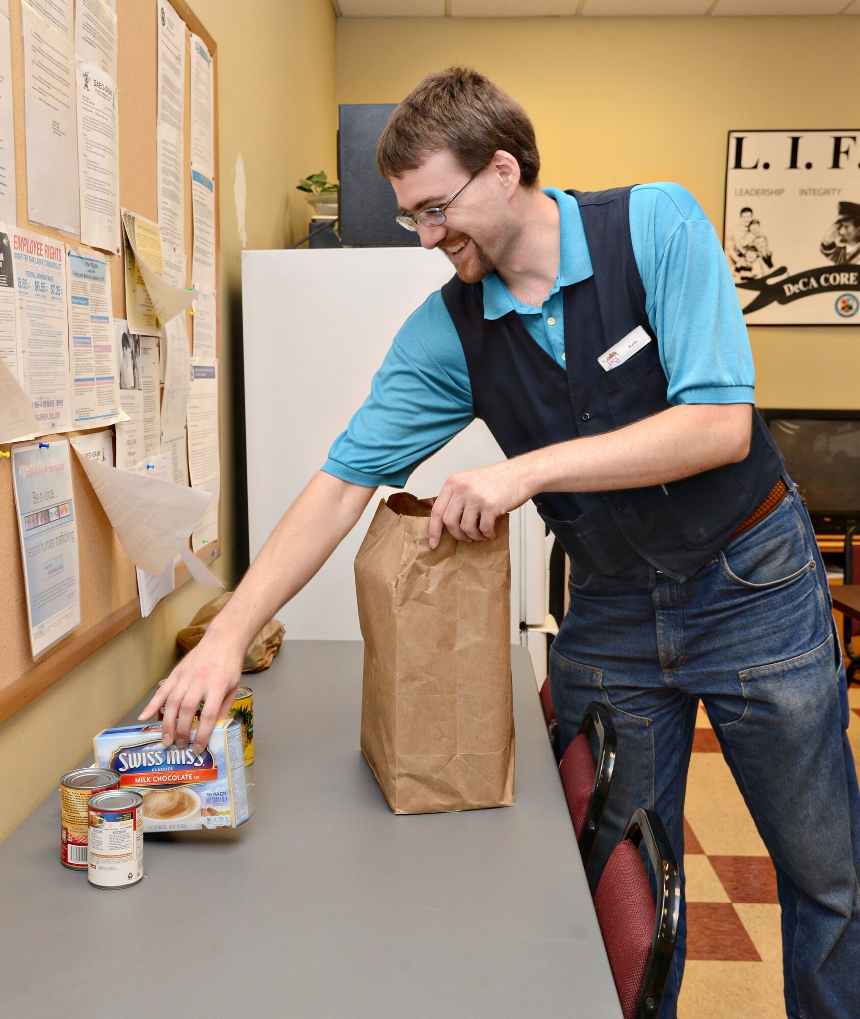 Kurtis Conrad, a store associate at the Tinker Commissary, assembles a grocery bag full of food items for the 2015 Feds Feed Families Food Drive Campaign. The bags cost no more than $10 and are located at the front of the store for purchase. The commissary will then donate the purchased bags to the campaign. The commissary has already sold 200 bags, which totals 1,700 pounds of food to be donated. Other donation collection boxes are located at the Youth Center, Bldg. 460 (72nd Air Base Wing Headquarters), Bldg. 3001 (flagpole entrance), and the Balfour Beatty Community Center.  (Air Force photo by Kelly White/Released)