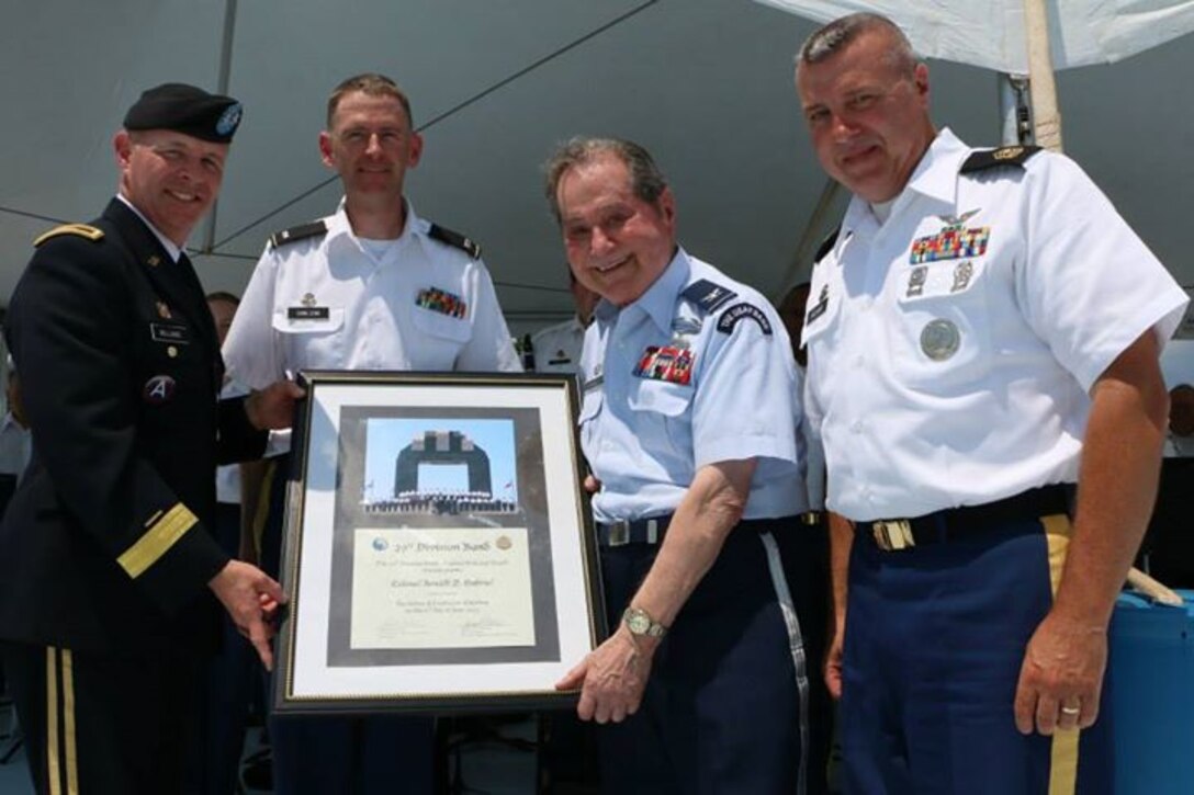 Retired Air Force Col. Arnald D. Gabriel, former 29th Infantry Division soldier and conductor emeritus of The U.S. Air Force Band, is named conductor emeritus of the 29th Division Band Virginia Army National Guard. Pictured from left to right: the Adjutant General of VaARNG, Maj. Gen. Timothy Williams, the 29th Division Band commander, Chief Warrant Officer 2 Don Carlson, retired Air Force Col. Arnald D. Gabriel, and 1st Sgt. David Helms, 29th Division Band. (VaARNG photo/released)
