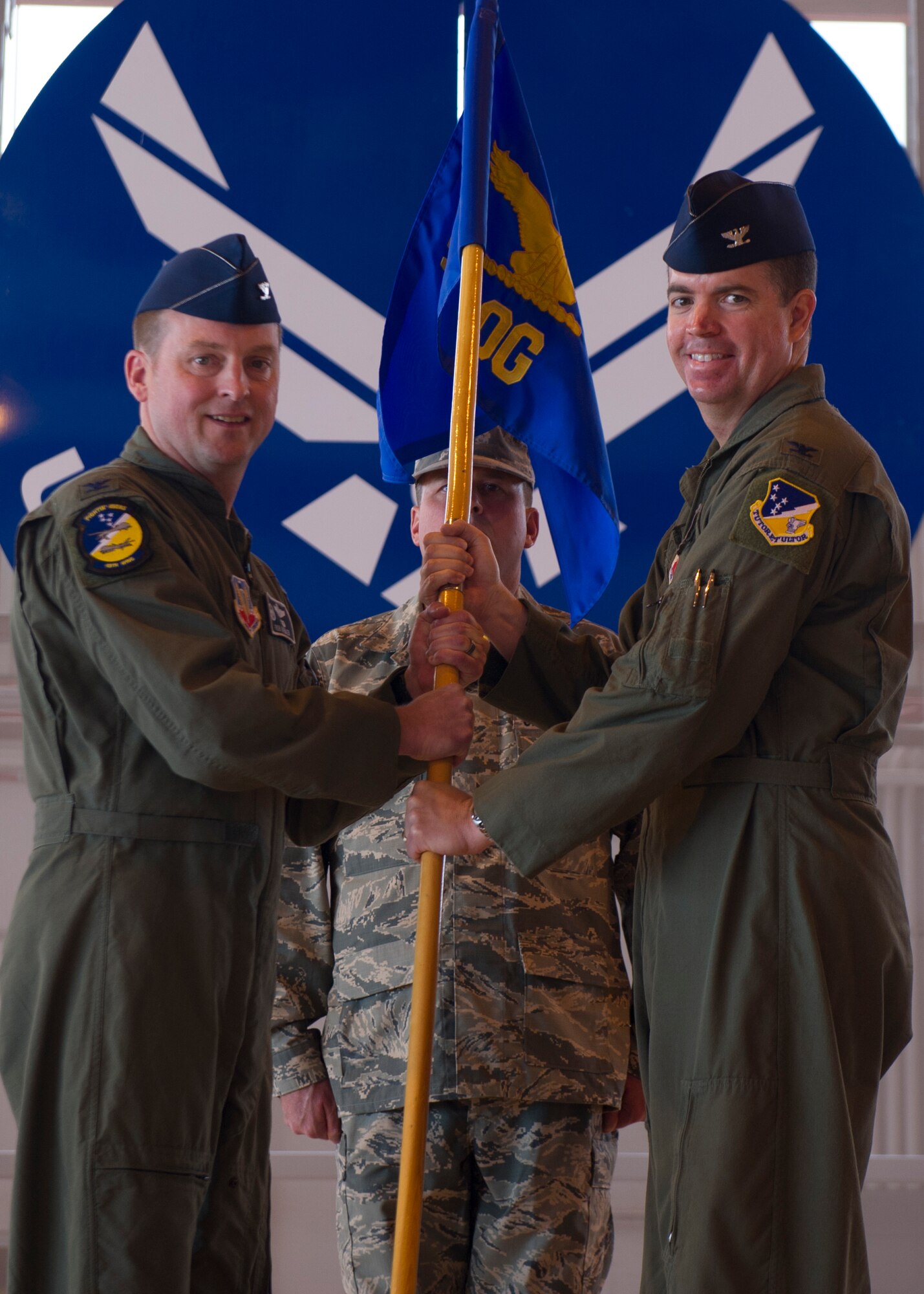 Col. Ryan Sherwood, incoming 49th Operations Group commander, receives the 49th OG guidon from Col. Robert Kiebler, 49th Wing commander, during the 49th OG Change of Command at Holloman Air Force Base, N.M., June 19, 2015. During the ceremony, Col. Mark Hoehn relinquished command of the 49th OG to Col. Ryan Sherwood. (U.S. Air Force photo by Airman 1st Class Emily A. Kenney/Released)