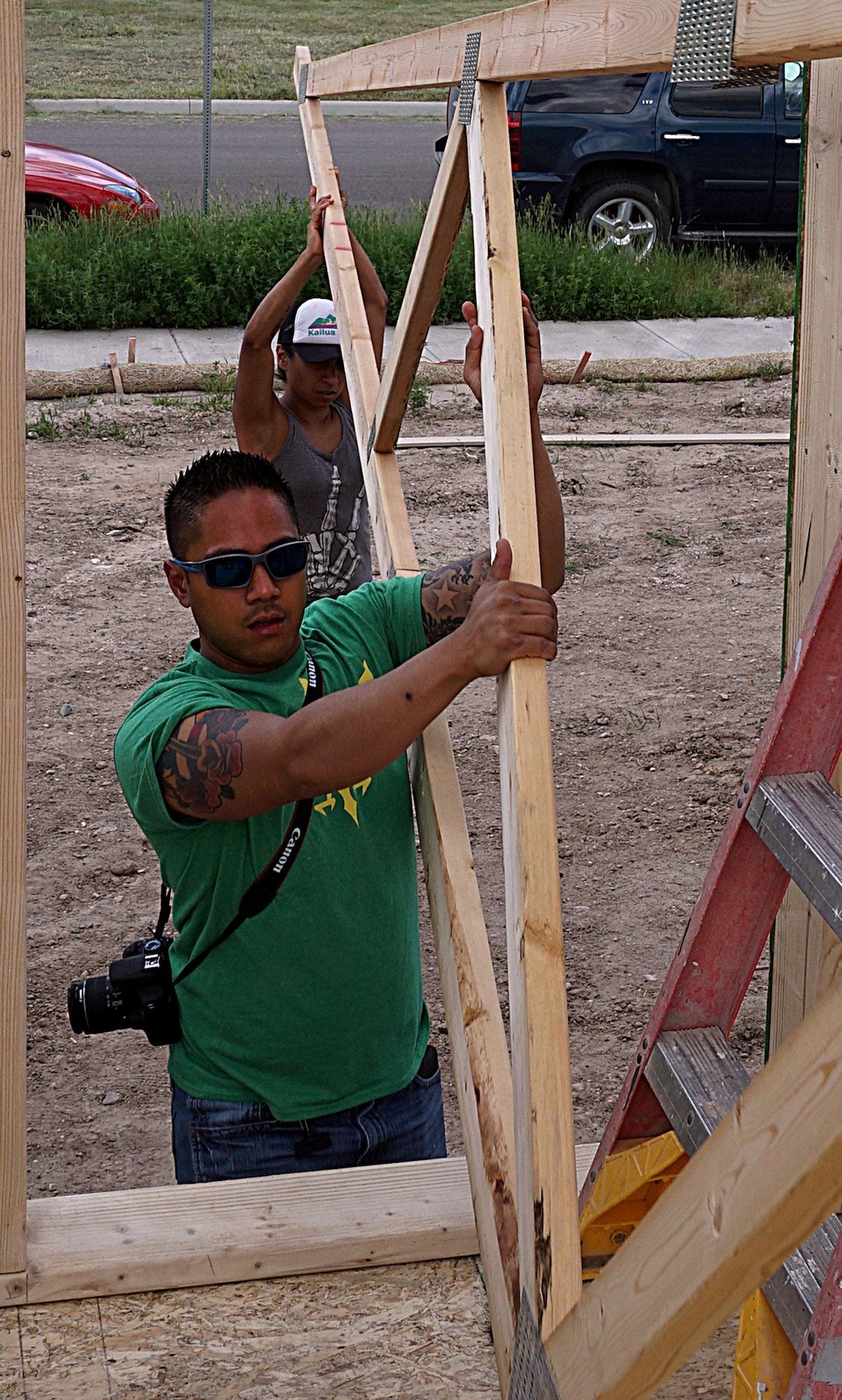 Senior Airmen Thorne Tayamen and Gloria Moctezuma, 90th Security Support Squadron, carry a rafter into a house June 14, 2015. Moctezuma and Tayamen volunteered with Habitat for Humanity to build a house in Cheyenne, Wyo. (U.S. Air Force photo by Airman 1st Class Brandon Valle)
