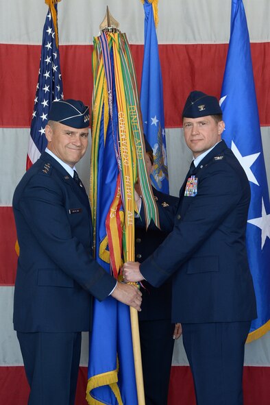 Lt. Gen. Chris Nowland passes the guidon to 388 Fighter Wing Commander Col. David B. Lyons at a change of command ceremony here June 19. (U.S. Air Force photo by Todd Cromar)