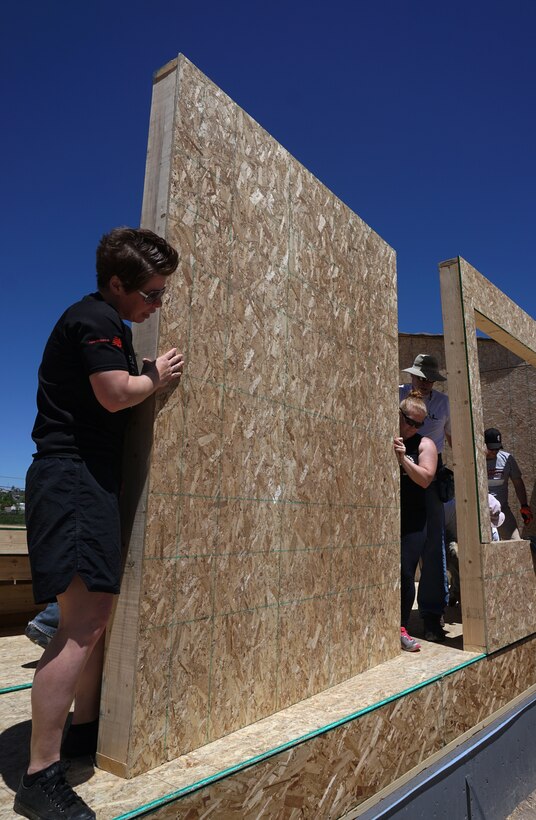 Senior Master Sgt. Jennifer Blackmarr, 90th Missile Wing Protocol Office, and Staff Sgt. Aubrie Jones, 90th Security Support Squadron, position a wall at the edge of the foundation during a Habitat for Humanity build June 14, 2015. Nine Airmen from F.E. Warren helped put up the frame of a house in Cheyenne, Wyo. (U.S. Air Force photo by Airman 1st Class Brandon Valle)