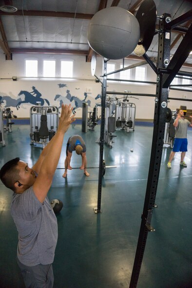 Capt. Brandon Castillo, 90th Operations Support Squadron, perform a medicine ball throw during an endurance training workout at the Independence Hall Fitness Center on F.E. Warren Air Force Base. Wyo., June 15, 2015. Castillo and others in his group work out together to provide each other support. (U.S. Air Force photo by Lan Kim)