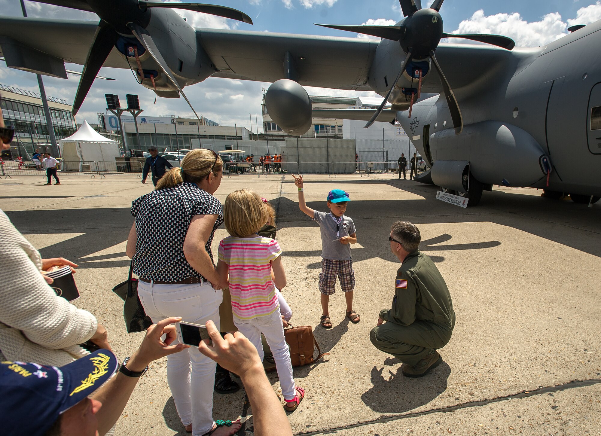 PARIS - WC-130J Weatherbird aircrews explain their mission to a family during the Paris Air Show at Le Bourget Airport, France, June 19, 2015. The Paris Air Show provides a collaborative opportunity to share and strengthen the U.S. and European strategic partnership that has been forged during the last seven decades and is built on a foundation of shared values, experiences and vision. The event is expected to bring in 315,000 people, a record 2,215 companies, 150 aircraft, and will span 324,000 square meters. (U.S. Air Force photo/ Tech. Sgt. Ryan Crane)