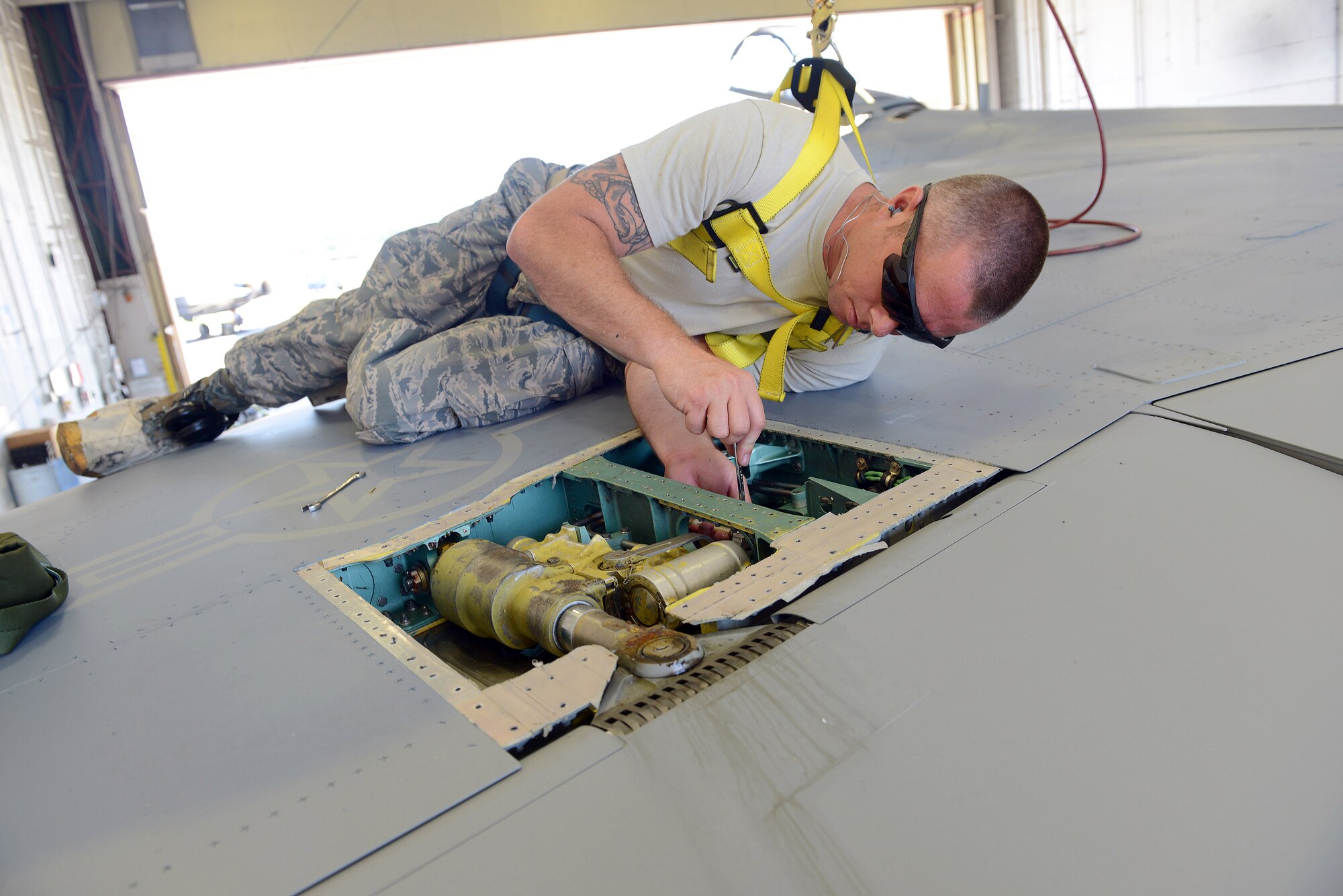 Tech. Sgt. Brandon Fitzpatrick, F-15 Functional Test, rigs flight controls on an F-15
Eagle in preparation of a functional test flight. Fall protection gear is a requirement for performing such repairs atop the aircraft. (U.S. Air Force photo by Tommie Horton)