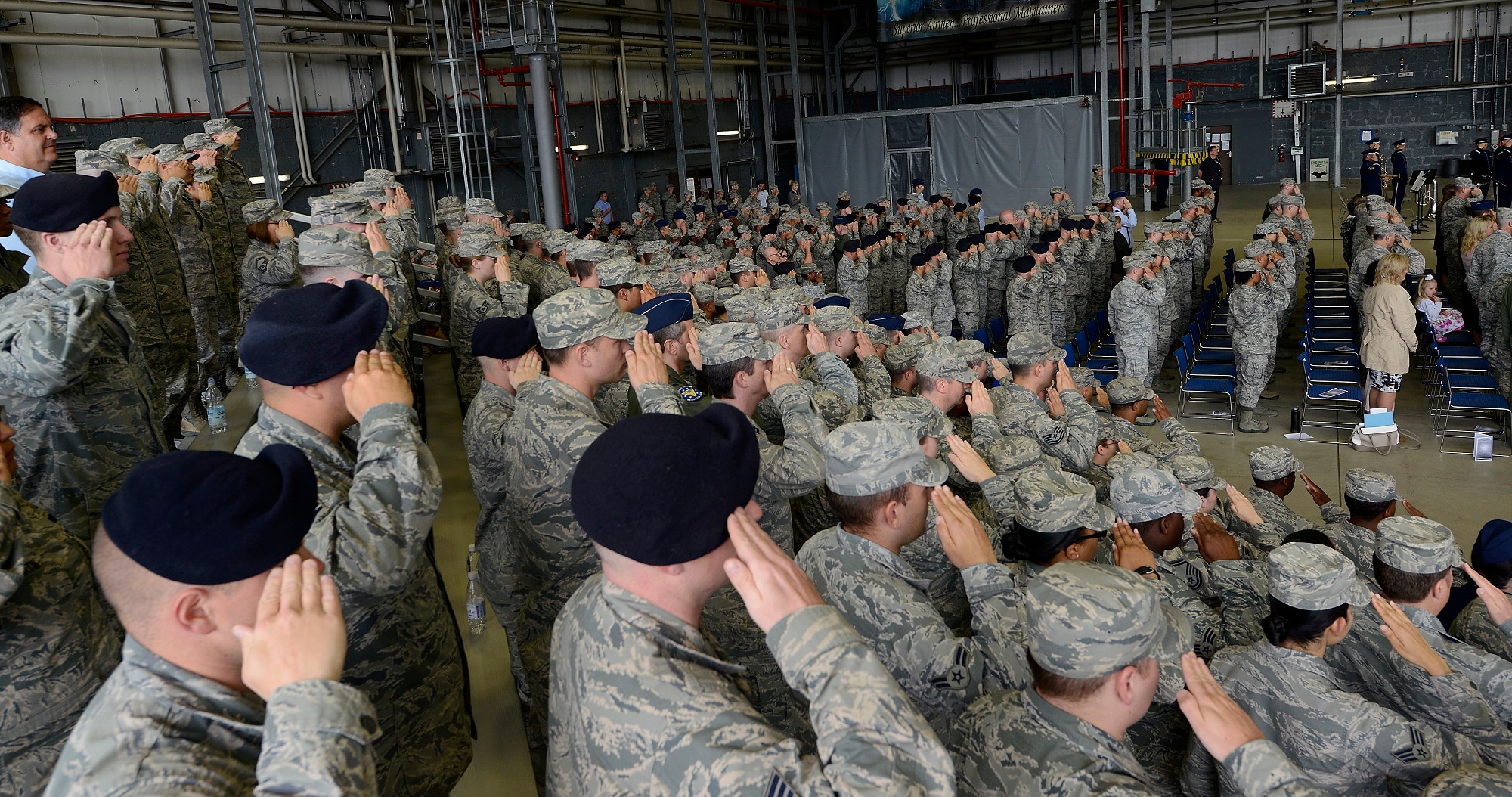 Airmen salute while the base honor guard posts the colors during the 86th Airlift Wing change of command ceremony June 19, 2015, at Ramstein Air Base, Germany. Brig. Gen. Jon T. Thomas assumed command of the largest wing in Europe from Brig. Gen. Patrick X. Mordente. (U.S. Air Force photo/Airman 1st Class Tryphena Mayhugh)
