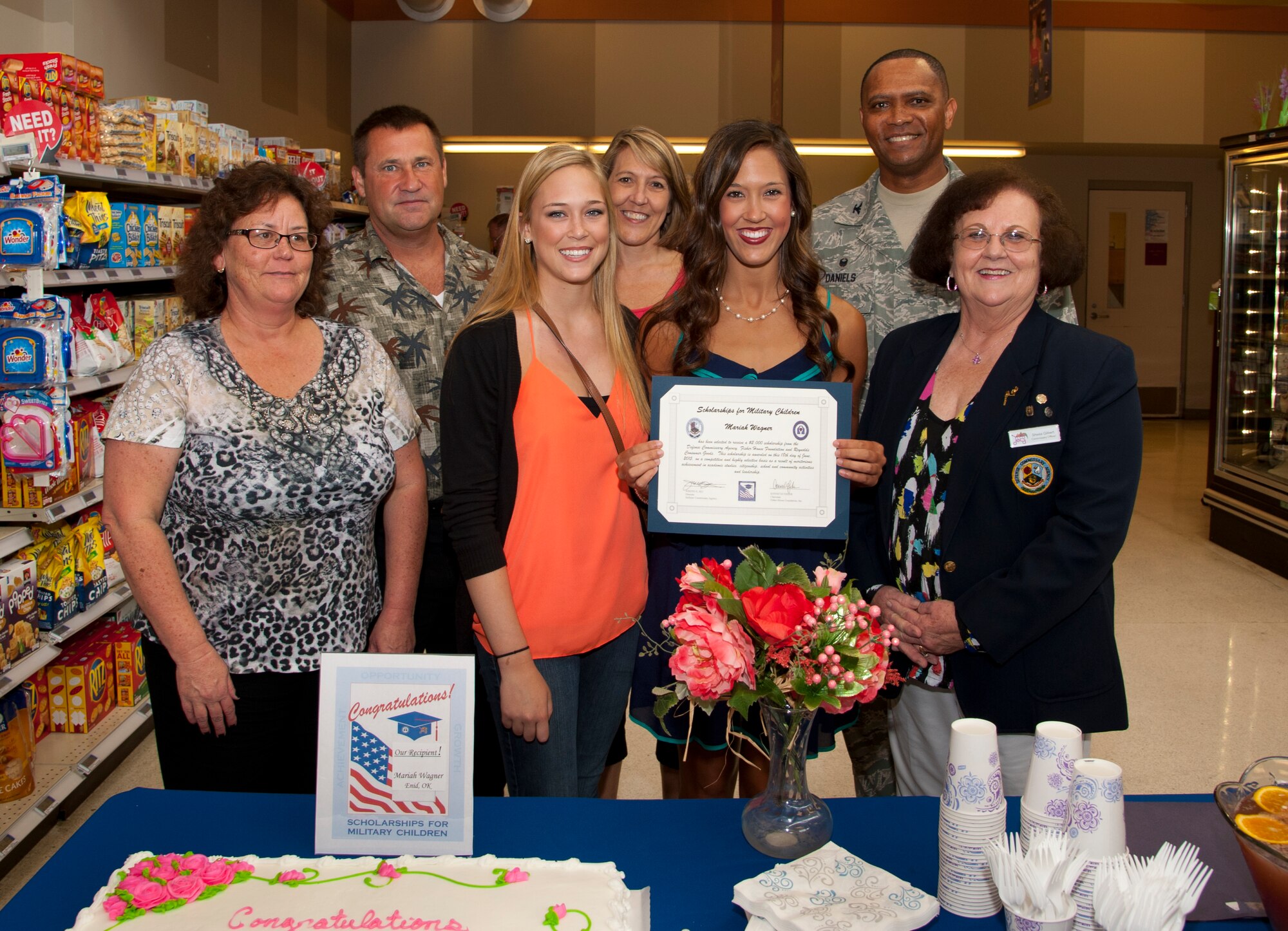 Mariah Wagner (center) holds a certificate for a $2,000 scholarship from the Defense Commissary Agency that was presented June 18 in the Vance Air Force Base Commissary by Sheila Gilbert, the Vance Commissary director, and Col. Christopher Daniels, the 71st Mission Support Group commander. Wagner is the daughter of a retired Air Force lieutenant colonel and just completed her second year at the University of Central Oklahoma in Edmond, Oklahoma. (U.S. Air Force photo / Tech. Sgt. James Bolinger)