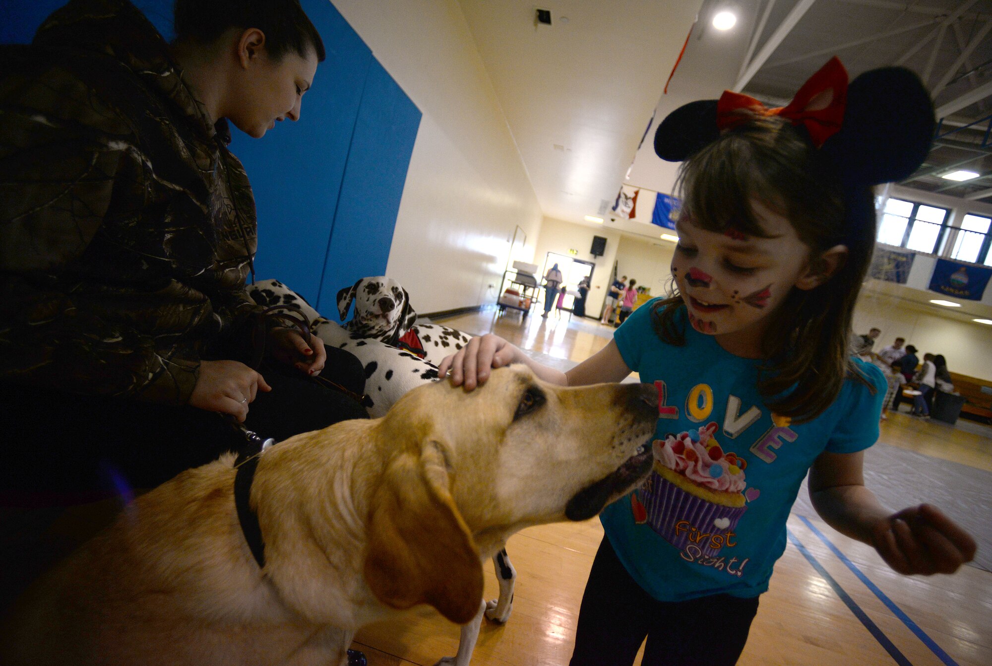Loreleis Rice, 4, daughter of U.S. Air Force Staff Sgt. Andrew Rice, 48th Munitions Squadron conventional maintenance crew chief, pets a therapy dog from Pets Enriching Troops during a Hearts Apart event held by the 100th Communications Squadron June 17, 2015, on RAF Mildenhall, England. The Hearts Apart event is held on a monthly basis for families of deployed Airmen. (U.S. Air Force photo by Senior Airman Christine Halan/Released)  