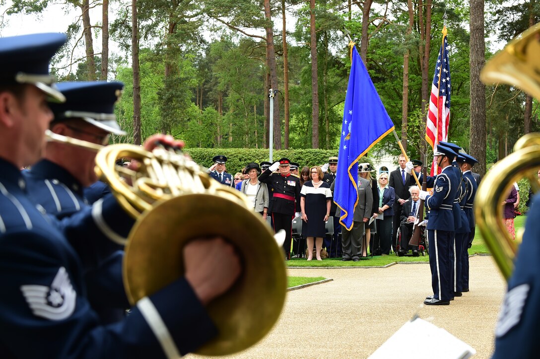 Airmen from the U.S. Air Forces Europe and Africa Band, play the American National Anthem as Airmen from the 422nd Air Base Group Honor Guard present the colors, during the Memorial Day ceremony at Brookwood American Military Cemetery, United Kingdom, May 24, 2015. The first American Service member burial was held May 1918, for members of the American Expeditionary Forces who lost their lives in Great Britain, the surrounding waters, from Influenza, and as a result of wounds suffered in France during World War I. (U.S. Air Force photo by Tech. Sgt. Chrissy Best/Released)